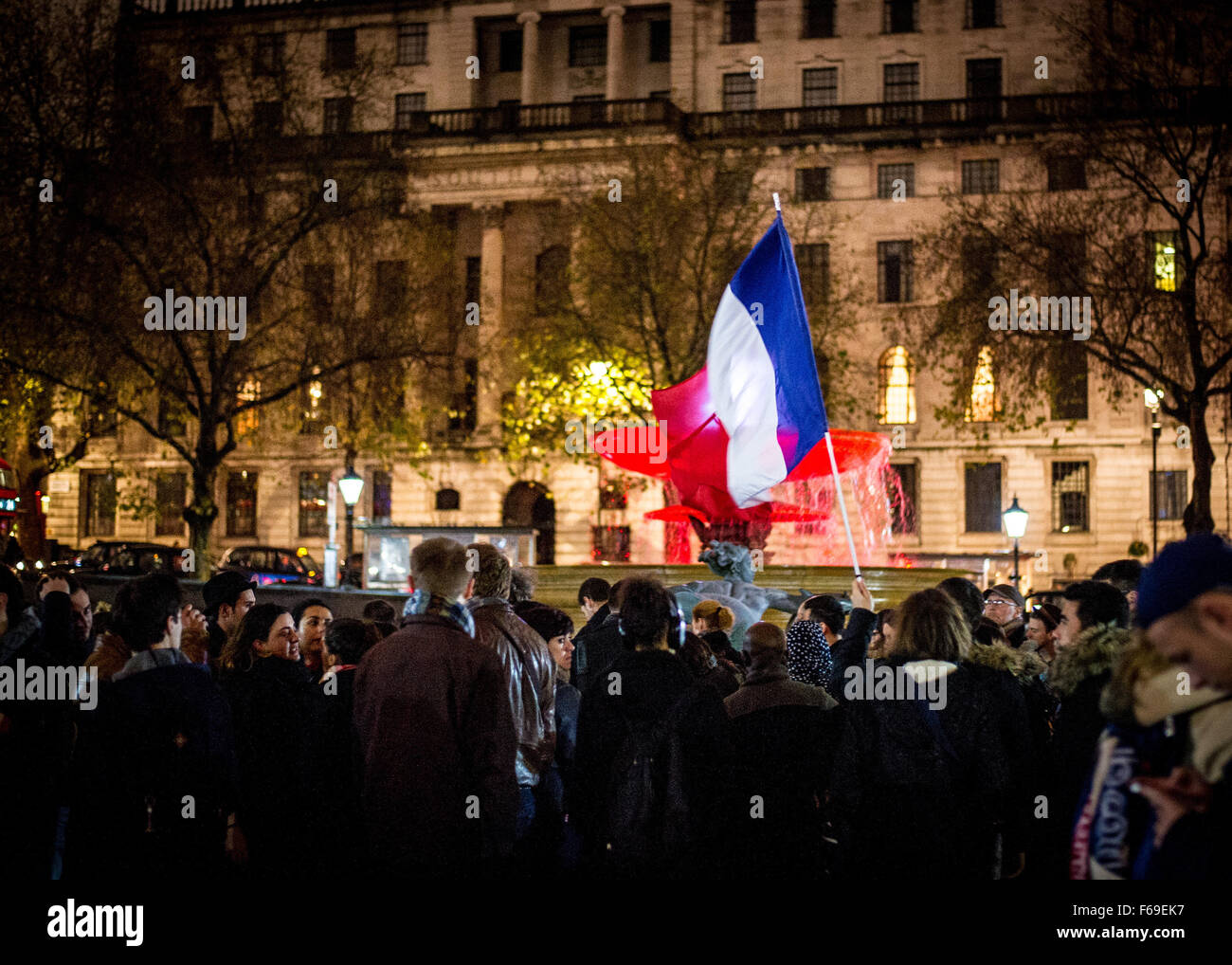 London, UK. 14. November 2015. Tausende versammeln sich am Trafalgar Square für ein Candle-Light-Mahnwache in Solidarität mit den Opfern von gestern Abend Terroristen Anschläge in Paris. Die National Portrait Gallery ist mit den Farben der französischen Tricolore Flagge beleuchtet. Stockfoto