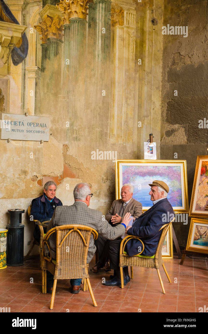 Eine Gruppe von vier Männern sitzen an einem Tisch und unterhalten sich in der Sorrento Mens Club. Stockfoto