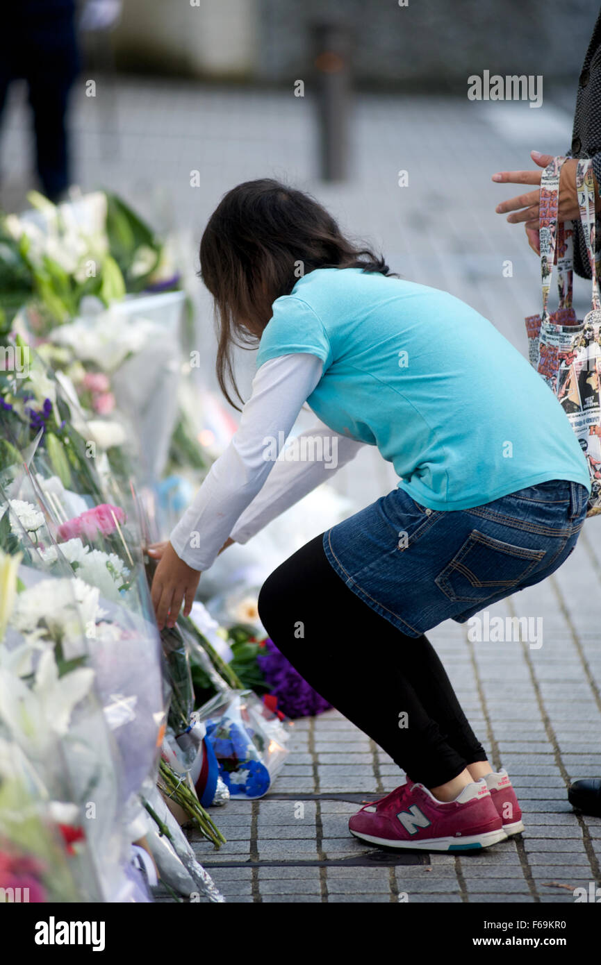 Ein japanisches Mädchen legt Blumen vor der französischen Botschaft in Tokio, nach den Terroranschlägen in Paris am 13. November. Stockfoto