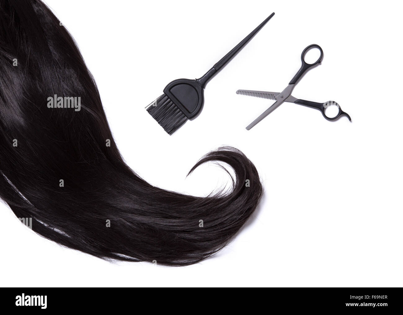 Draufsicht auf schwarz glänzendes Haar, Farbstoff Haarbürste und professionelle Scheren, isoliert auf weißem Hintergrund Stockfoto