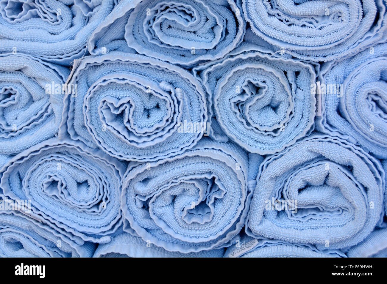 Zusammenfassung Hintergrund Endansicht Nahaufnahme von blau aufgerollt Handtücher im Stapel neben Pool wartet auf Einsatz von Kreuzfahrt-Passagiere auf Liegestühlen Stockfoto