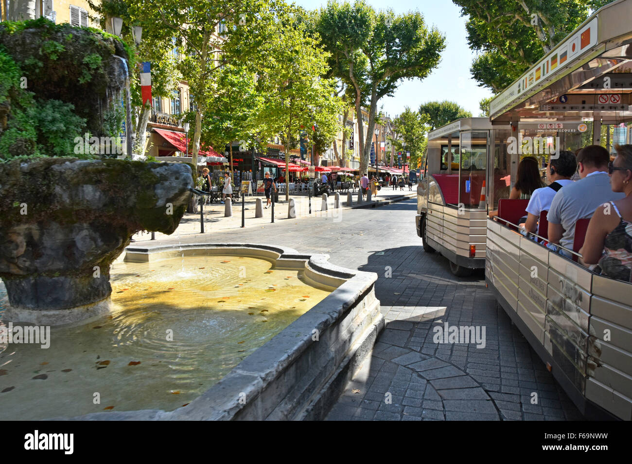 Aix en Provence Südfrankreich Touristen auf Besichtigungstouren mit dem Landzug auf dem Boulevard Cours Mirabeau vorbei an der französischen Fontaine des Neuf-Canons Stockfoto