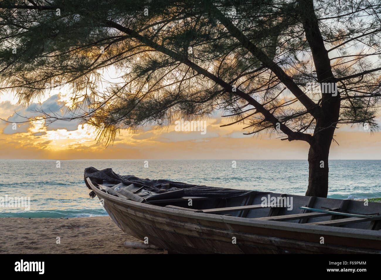 Sonnenuntergang über Mai Kao Beach in Phuket, Thailand mit Boot und Baum Stockfoto