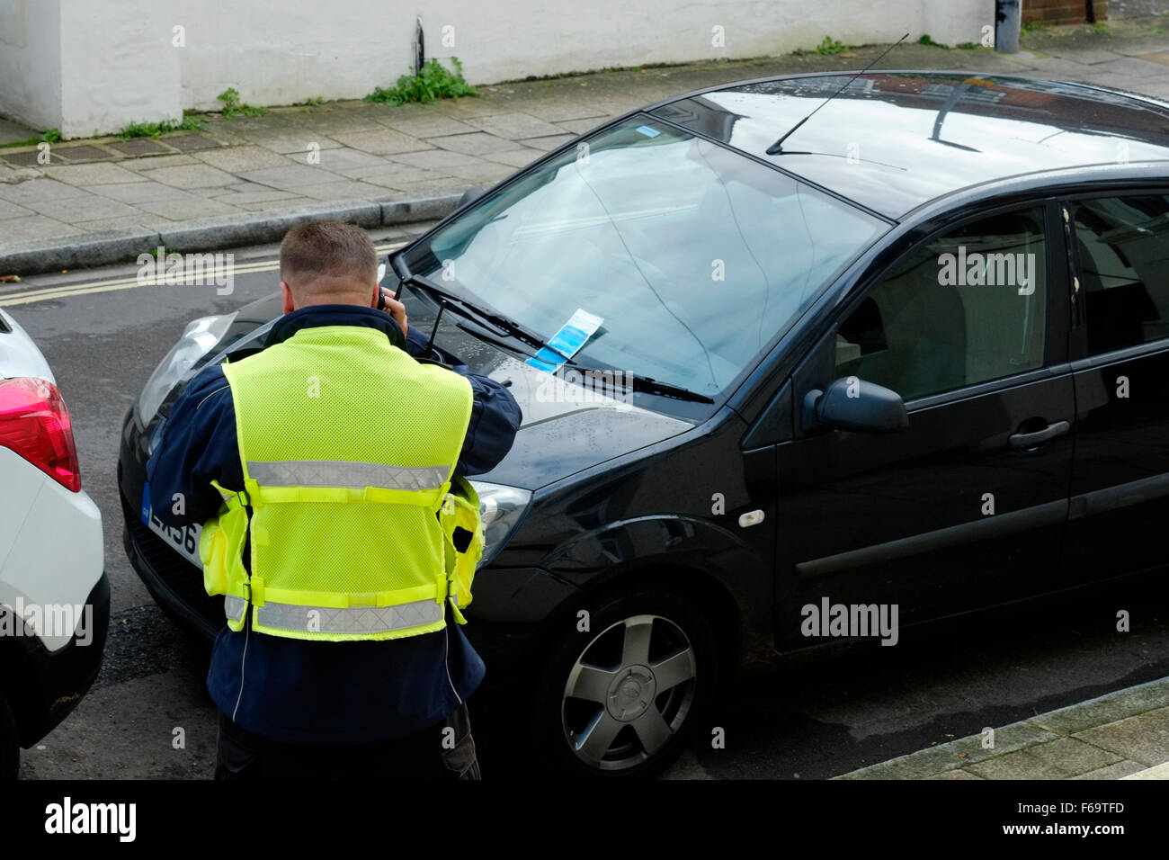 Traffic Warden Erteilung eine Parkkarte für einen Verstoß gegen England uk Stockfoto
