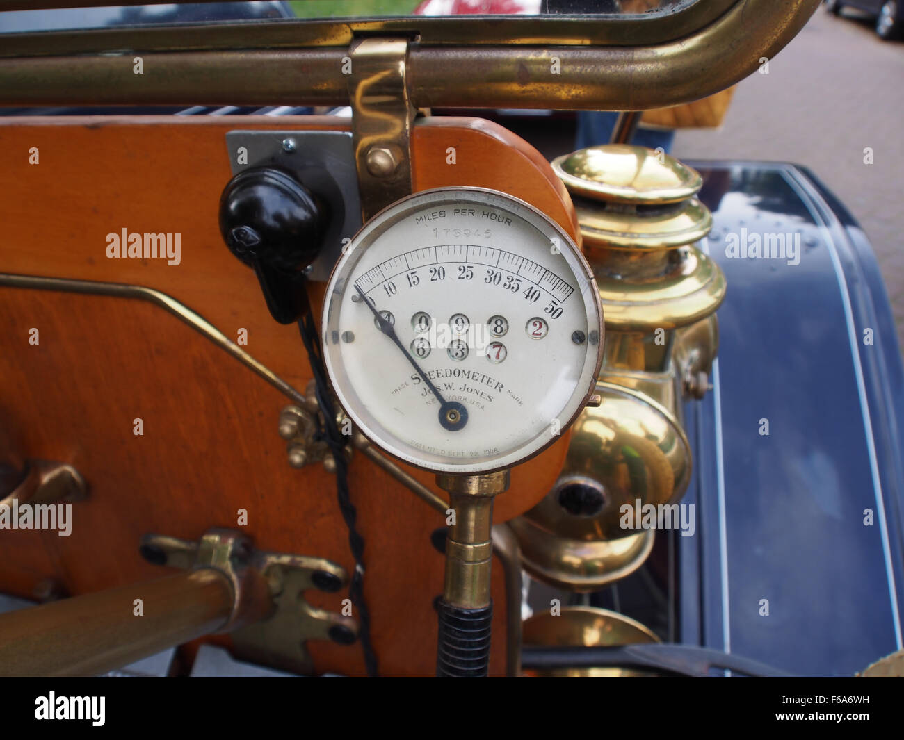 Das Bild zeigt ein 1910er-Buick-Auto neben einem großen Containerschiff an einem stark frequentierten Hafen. Die Szene erfasst Logistik und Transport mit Kränen, Lagercontainern und verschiedenen Gütern, die beladen oder entladen werden, wie Tanker, Getreide und Kohle. Sie verdeutlicht die Komplexität und den Umfang des Seehandels und des Frachtumschlags Anfang des 20. Jahrhunderts. Stockfoto