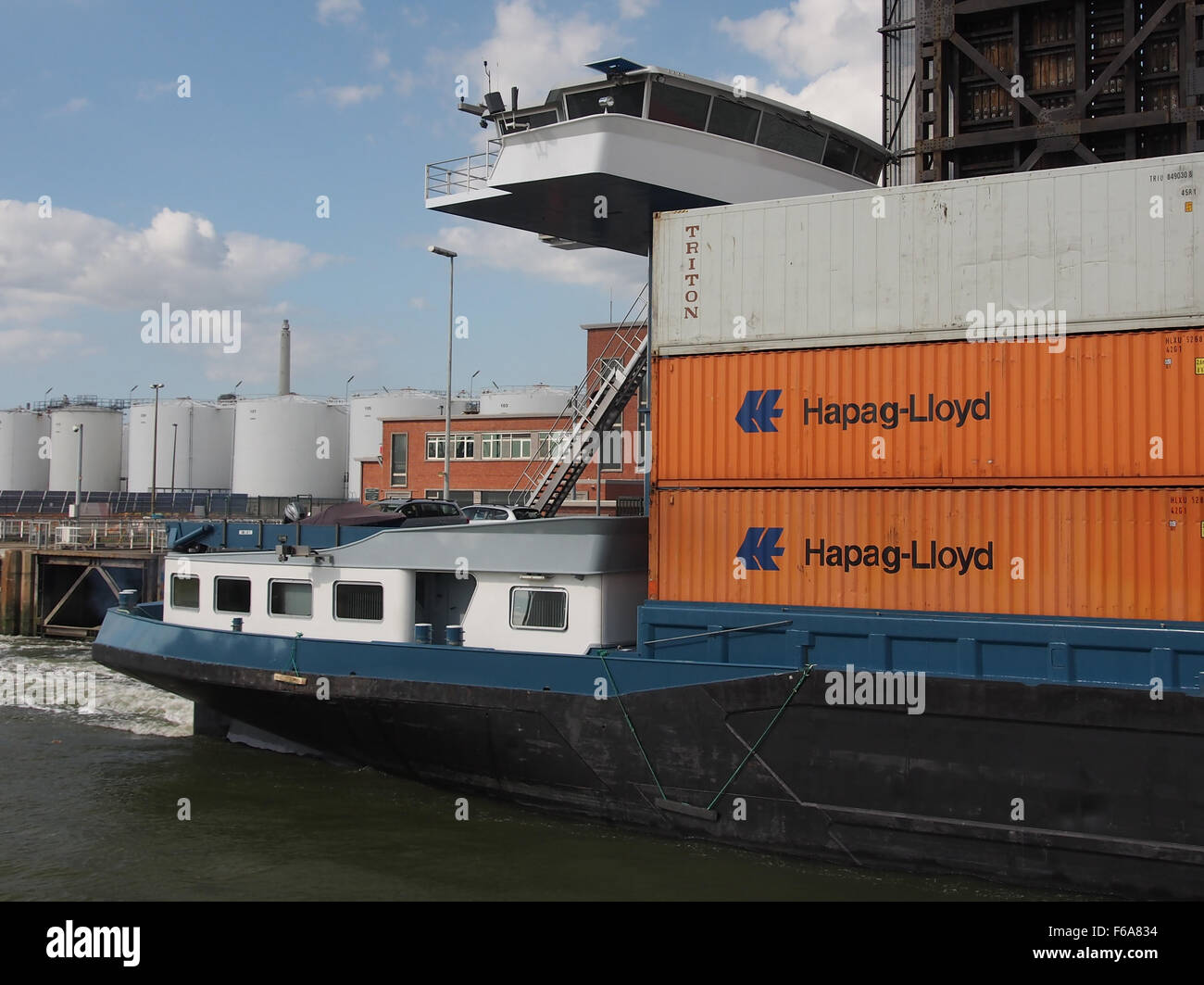 Das Schiff ENI 02329377 ist an der Boudewijnsluis, einem wichtigen Kanal in Belgien, zu sehen, der verschiedene Arten von Fracht befördert, darunter allgemeine Güter, Kohle und Getreide. Das Schiff ist mit Kränen für effizientes Be- und Entladen am Dock ausgestattet. Stockfoto