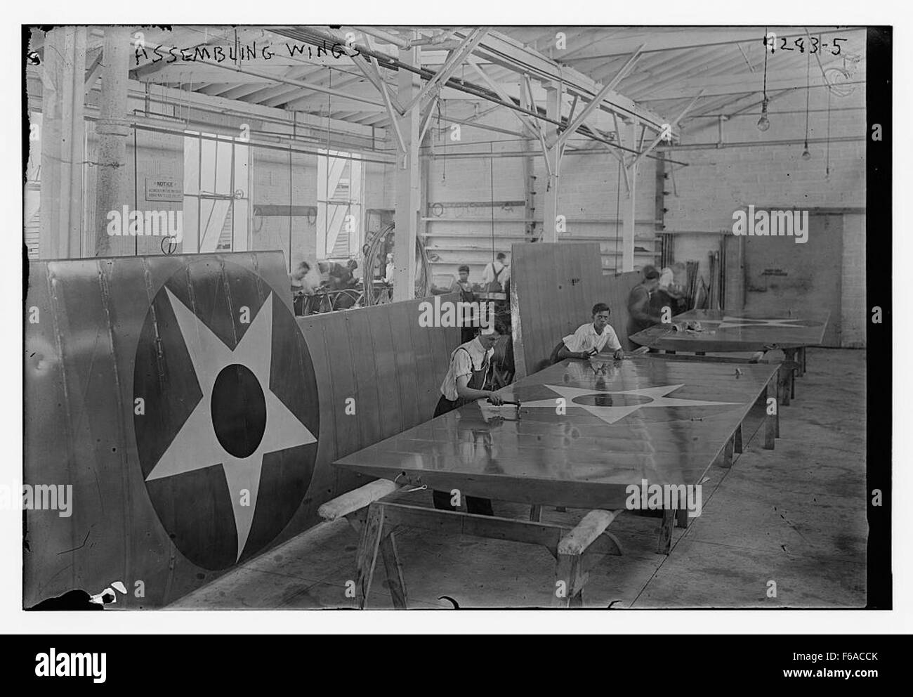 Ein Foto von Arbeitern, die Flugzeugflügel zusammenbauen und die Anfänge der Massenproduktion in der Luftfahrtindustrie festhalten. Diese Flügel sind ein wichtiger Bestandteil des Flugzeugbaus und stellen einen Meilenstein in der Entwicklung der Luftfahrt dar. Stockfoto