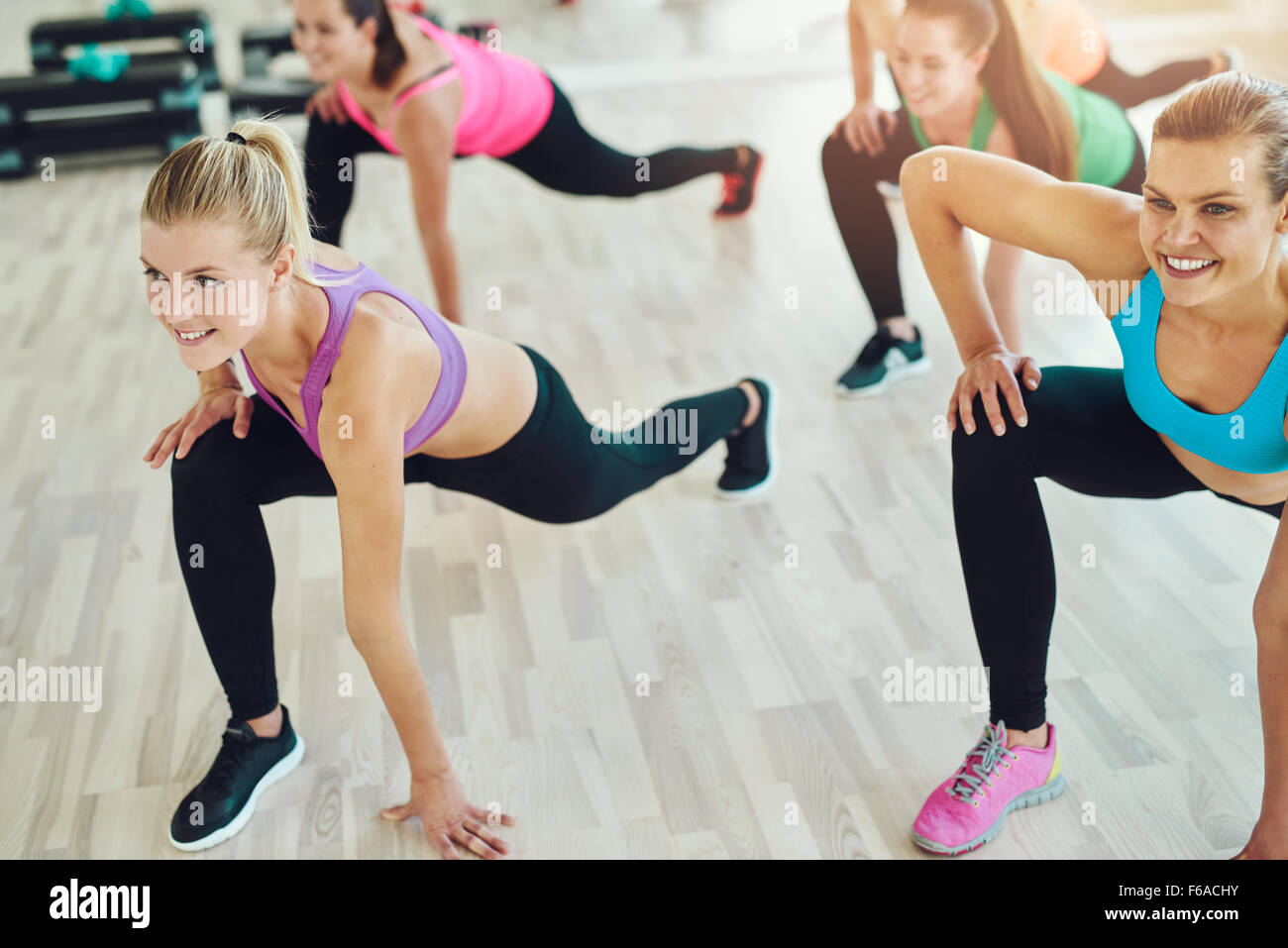 Fitness, Sport, Training und Lifestyle Konzept - Gruppe der lächelnden Frauen Stretching in der Turnhalle Stockfoto