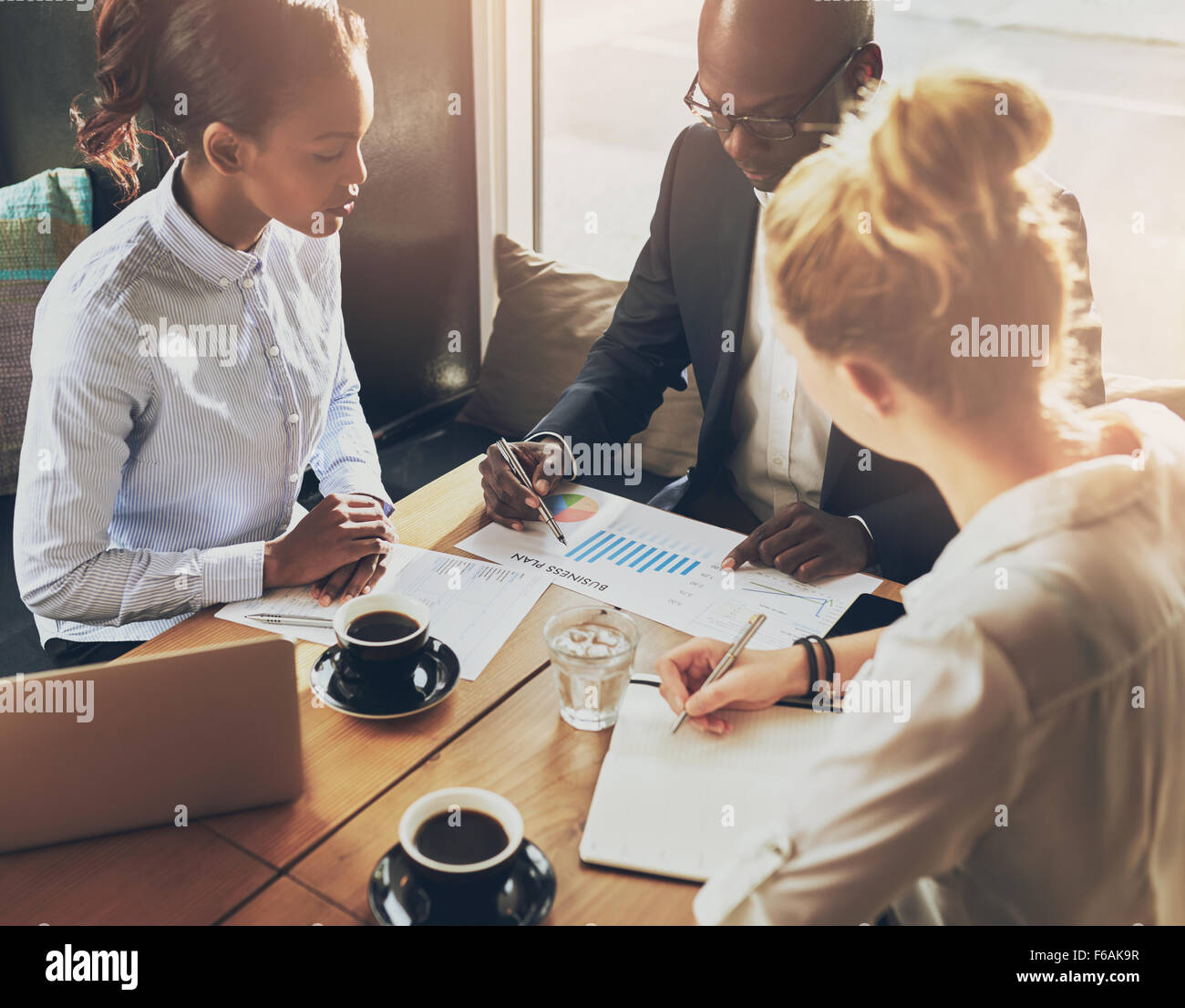 Geschäftsleute über die Tabellen und Grafiken zeigen die Ergebnisse ihrer erfolgreichen Teamarbeit, multi-ethnische Business Stockfoto