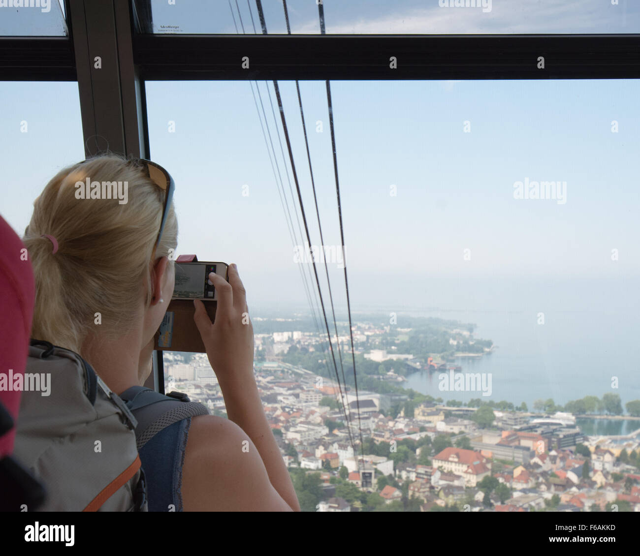 junge Frau nehmen Foto von den Blick auf den Bodensee von der Pfänderbahn-Seilbahn, Bregenz, Österreich Stockfoto