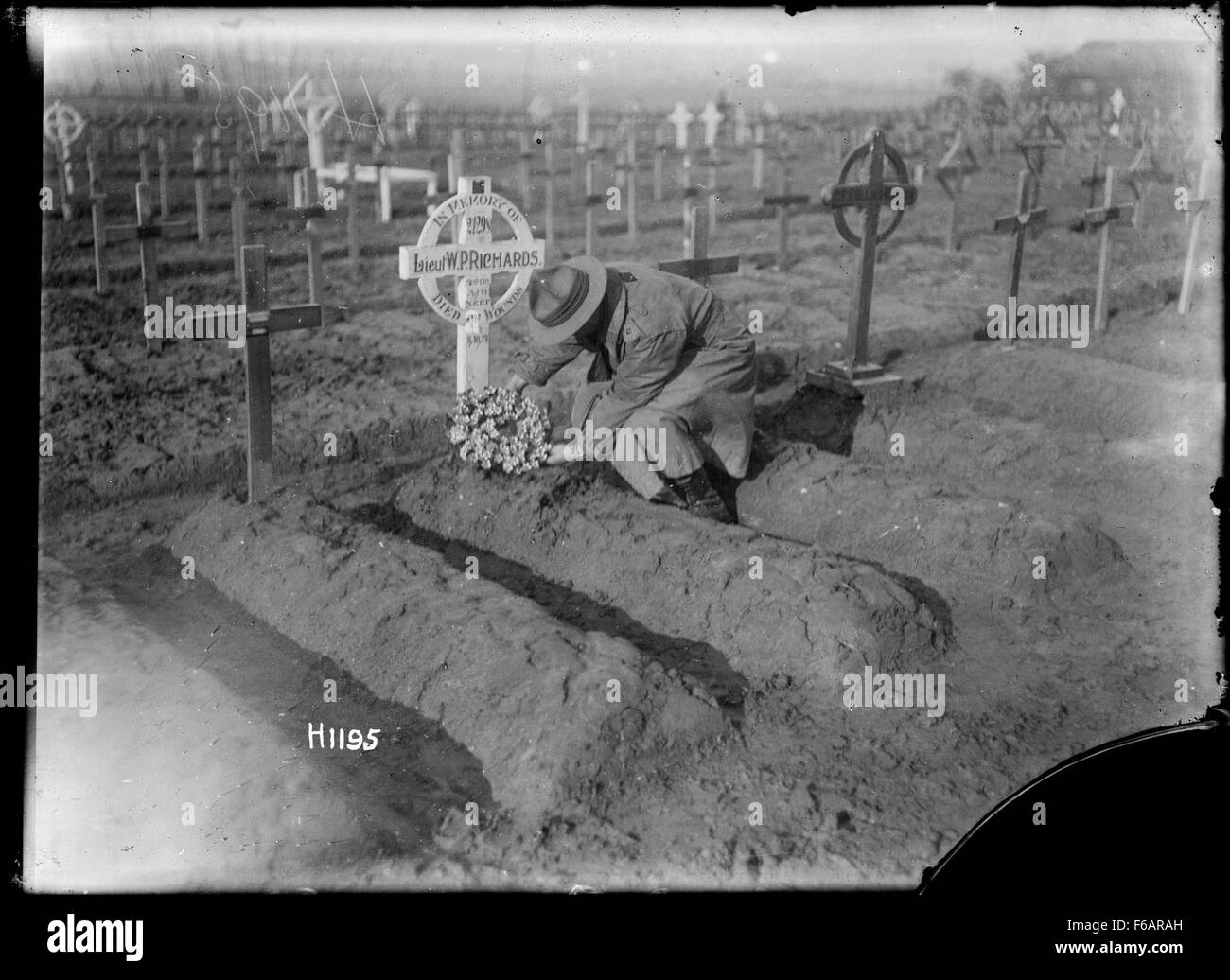 Dieses Bild zeigt einen Offizier aus Auckland, der einen Kranz auf einem Grab platziert, der Respekt und Erinnerung symbolisiert. Der Akt spiegelt die Ehre derjenigen wider, die gedient haben oder vergangen sind, möglicherweise verbunden mit einer Gedenkfeier oder Gedenkveranstaltung. Er unterstreicht den Akt der Anerkennung im Rahmen des Militär- oder Zivildienstes. Stockfoto