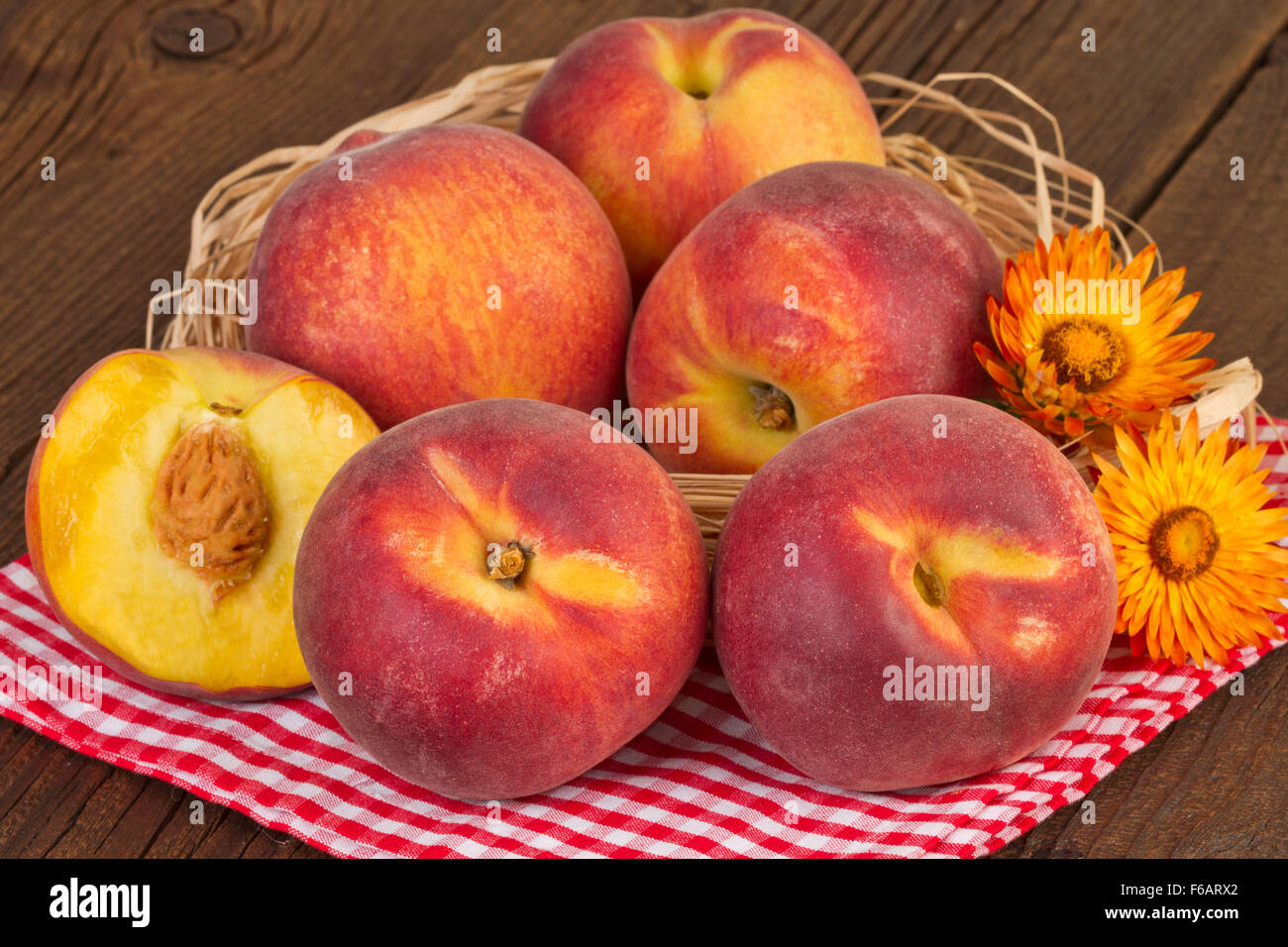Pfirsiche auf rot karierten Tischdecke Stockfoto