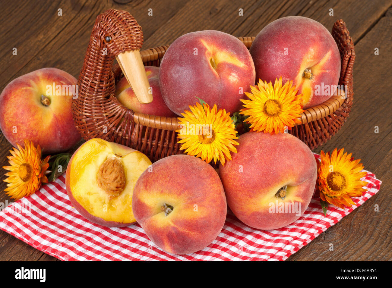 Pfirsiche in Vintage Korb auf karierten rote Tischdecke-Herbst-Stilleben Stockfoto