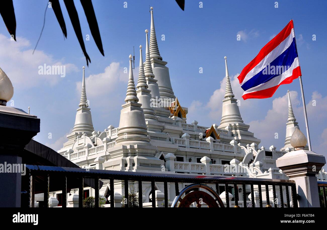 Samut Prakan, Thailand: Strahlend Wat Asoke mit seinen sieben Ring spired Chedis und die roten, weißen und blauen thailändische Flagge Stockfoto