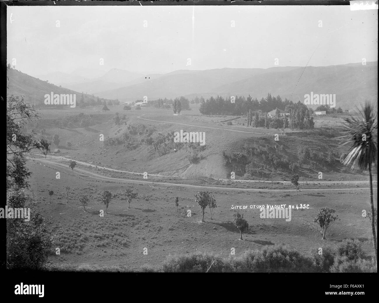 Dieses Kunstwerk präsentiert einen allgemeinen Blick auf die ländliche Landschaft in der Nähe einer namenlosen Siedlung. Das Stück fängt die Gelassenheit der Landschaft mit einem Schwerpunkt auf natürlicher Schönheit, sanften Hügeln und landwirtschaftlichem Leben ein. Stockfoto