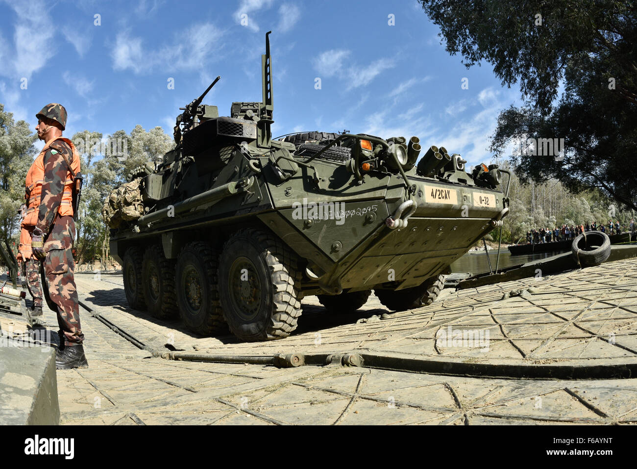 Mitglieder der ungarischen Streitkräfte Wachen als US-Soldaten, die 4. Staffel, 2. Kavallerie-Regiment Verhalten eine bewusste Wasser in ihren M1126 Stryker bekämpfen Fahrzeugen über einen Bypass Überbrückung Website während Dragoon Kreuzung überqueren, eine taktische Straße marschieren zur Unterstützung der Operation Atlantic zu beheben, in Györ, Ungarn, 17. September 2015 zugewiesen. Die USA und Partner Nationen durchgeführt Land-, See- und Luft ausübt und eine rotierende Präsenz beibehalten, um NATO Sicherheitsverpflichtungen in Europa zu stärken.  (US Armee-Foto von Sgt. William A. Tanner/freigegeben) Stockfoto