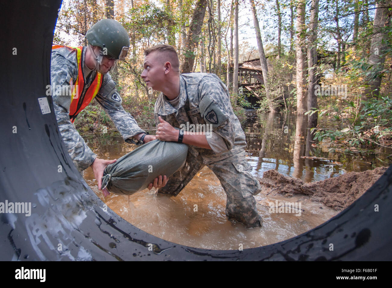 South Carolina Army National Guard 1st Lt. Benjamin Sternemann und Spc. Connor Ulyatt mit dem 1221st Engineering-Unternehmen von Graniteville, S.C., sichert einen Teil der Kanal Rohr mit Sandsäcken als ein Team von Ingenieuren arbeiten, eine gewaschene, Düker auf eine Lexington County Road in Gilbert, S.C., 24. Oktober 2015 zu ersetzen. Soldaten mit S.C. Army National Guard weiterhin direkten Unterstützung für Flut Erholung und Notfall Straße Reparaturen infolge der jüngsten Überschwemmungen. Der South Carolina National Guard in Zusammenarbeit mit Bund, Ländern und Gemeinden Notfallmanagement Agenturen und Ersthelfer. Stockfoto