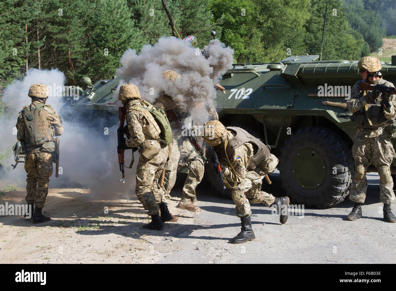 Ein Lehrer mit der ukrainischen Streitkräfte (Mitte) wirft eine Rauchgranate auf einem BTR-80 gepanzerte Truppentransporter als ukrainische Soldaten Verhalten Konvoi Operations training 27. Juli 2015, während schnelle Trident in Yavoriv, Ukraine. Rasche Trident ist eine langjährige US-Army in Europa führte kooperative Übung konzentrierte sich auf Operationen zur Wahrung und Stabilität. Mehr als 1.800 Mitarbeiter aus 18 Nationen sind an der Übung beteiligt. (Foto: US-Armee Sgt. Alexander Skripnichuk, 13. Public Affairs-Abteilung) Stockfoto