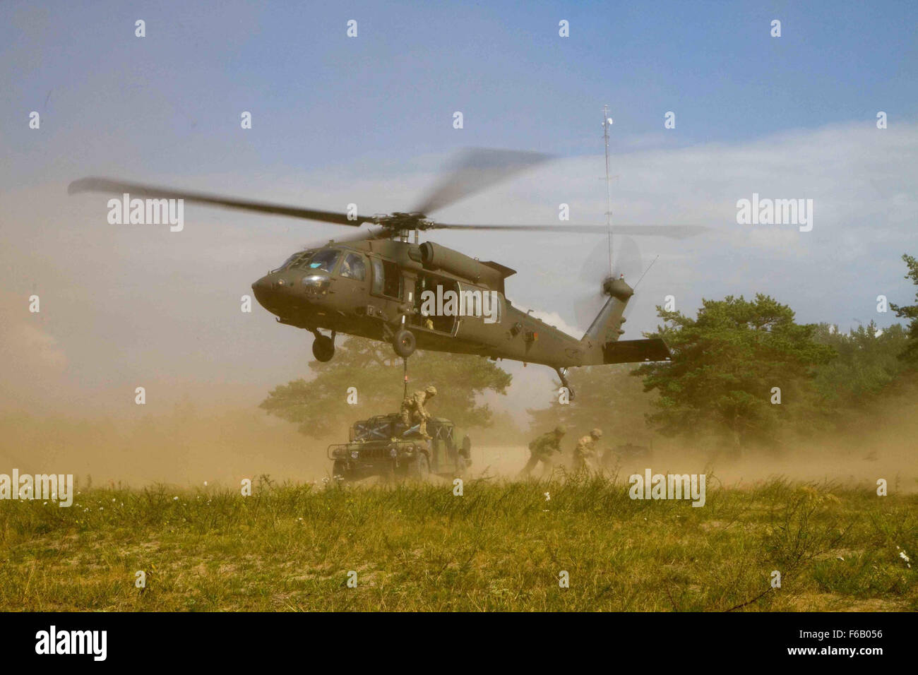 US-Soldaten zugewiesen B Company, 43. Angriff Hubschrauber-Bataillon, 3. Kavallerie-Regiment, 3. Infanterie-Division, schweben ihre UH - 60M Black Hawk Hubschrauber über Soldaten zugewiesen Dog Company, 1. Bataillon, 503. Infanterieregiment, 173. Infantry Brigade Combat Team (Airborne), 4. US-Infanteriedivision und litauischen Land Forces Soldaten zugewiesen, die Großherzogin Birutė Ulanen Bataillon (BUB), nachdem die Teams vor Ort erfolgreich Schlinge während des bilateralen Trainings genannt Ulanen Fury wird derzeit eine hohe Mobilität Multipurpose Wheeled Fahrzeuge (HMMWV) geladen statt auf die gen-Silvestras Stockfoto