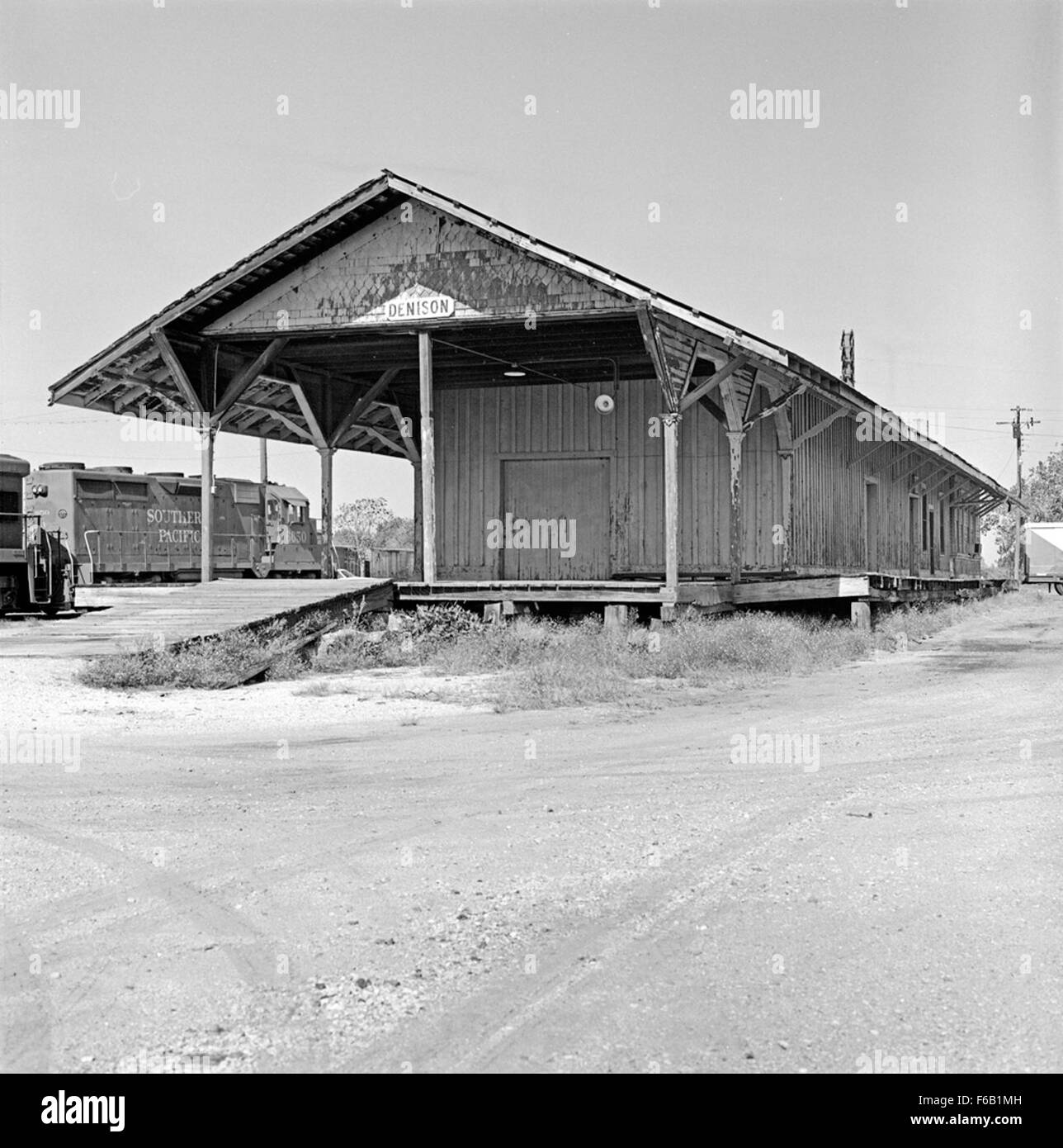 Dieses Foto zeigt eine Südpazifik-Frachtstation in Denison, Texas, die die geschäftige Aktivität von Eisenbahndepots und Gütertransporten zeigt. Das Bild unterstreicht die wichtige Rolle der Eisenbahn im Handel der Region. Stockfoto