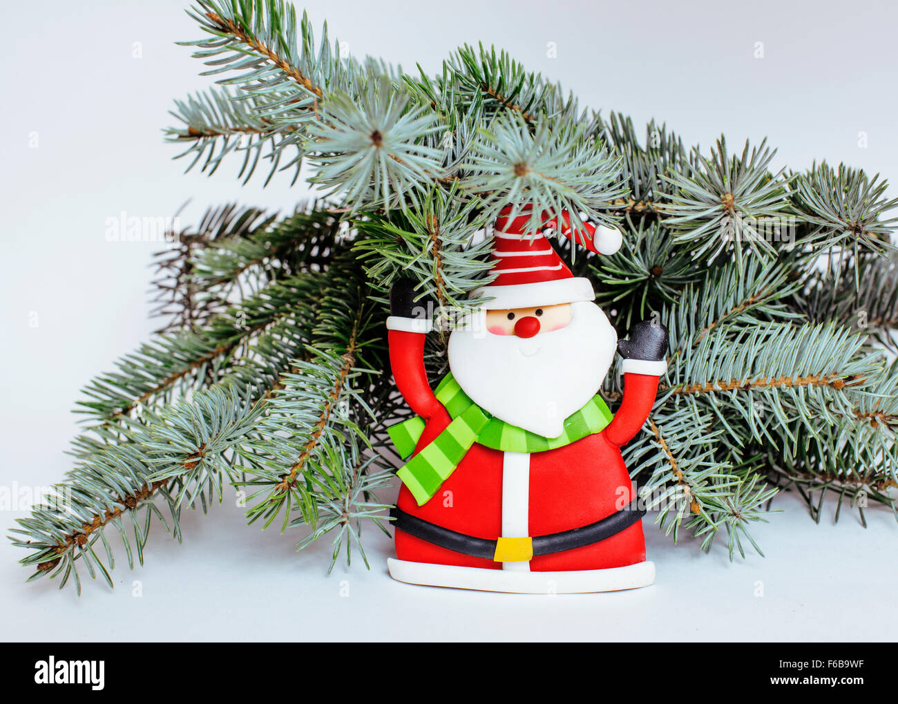 kleines Spielzeug von Santa Claus in rote Mütze und Schal, isoliert auf weiss Stockfoto