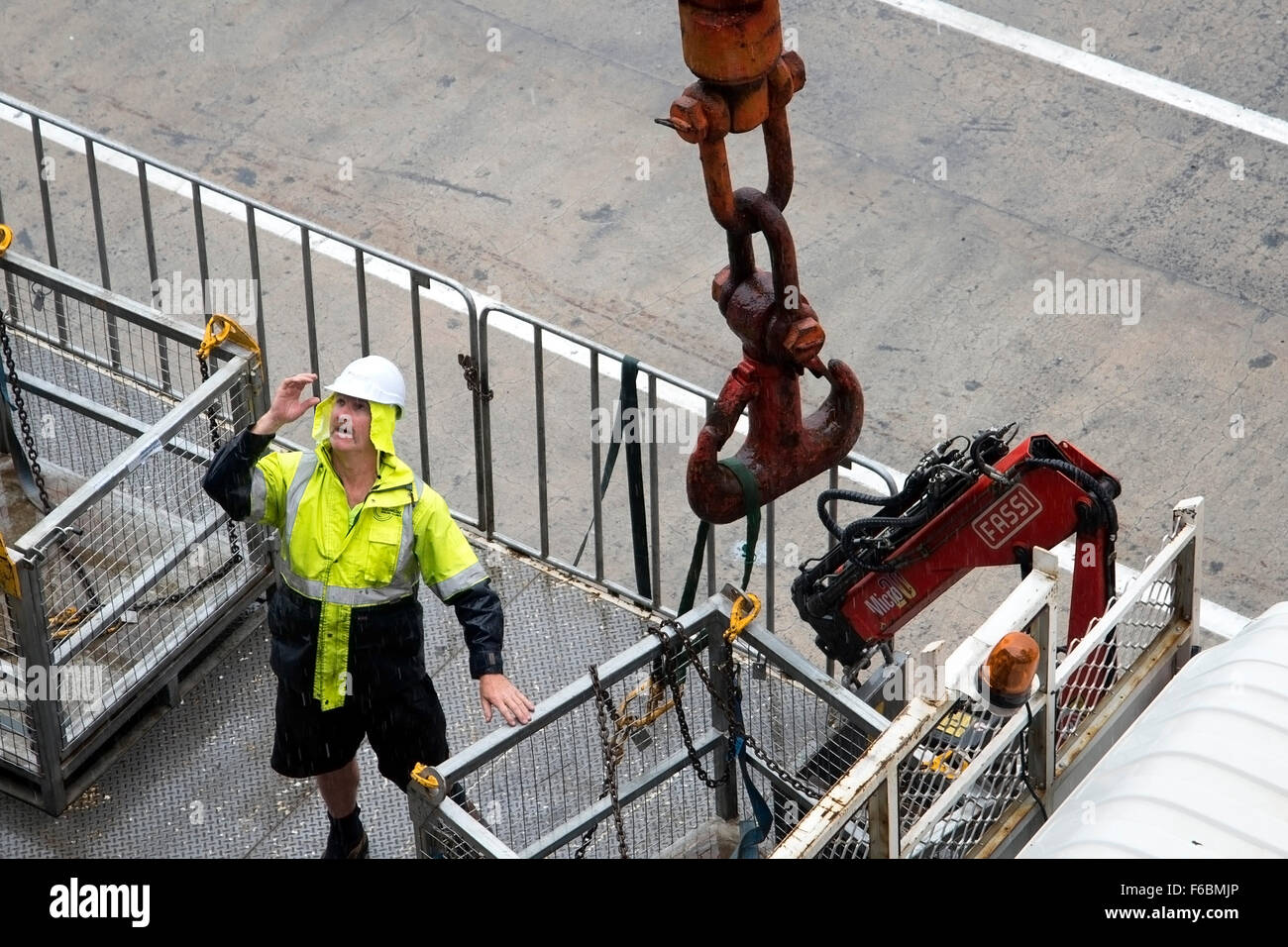 Hafenarbeiter am Kai schaut und ruft um Aufmerksamkeit in Port Melbourne, Australien Stockfoto
