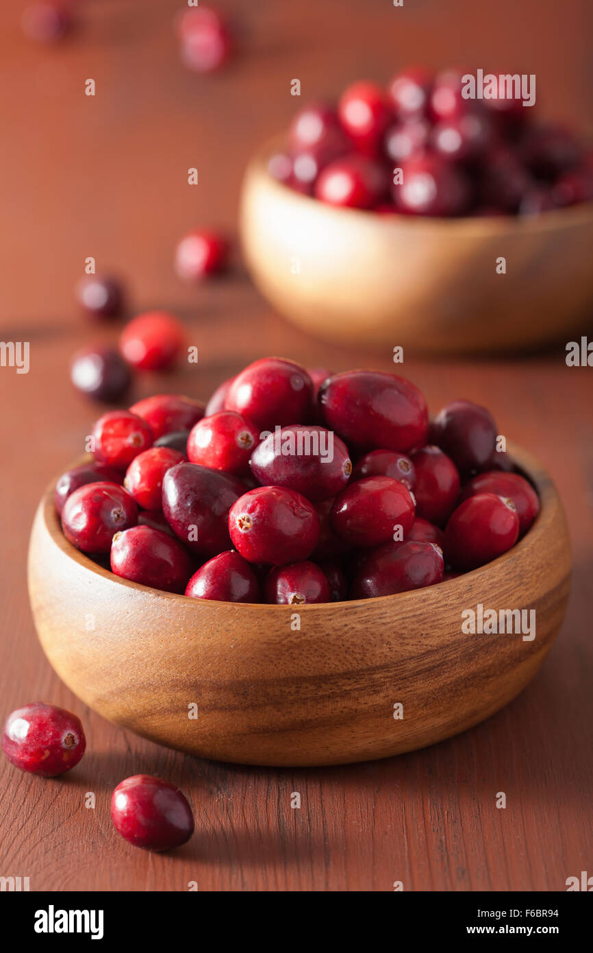 frische Preiselbeeren in Holzschalen über rustikalen Tisch Stockfoto