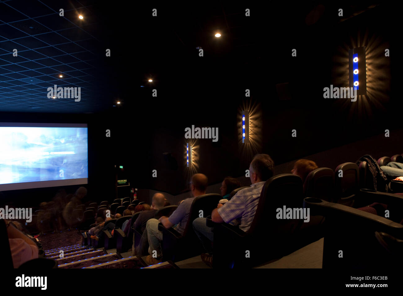 Innere Bild eines Kinos, zeigt der Bildschirm am unteren Rand das abgestufte Auditorium und das Publikum zum Film niederzulassen. Stockfoto