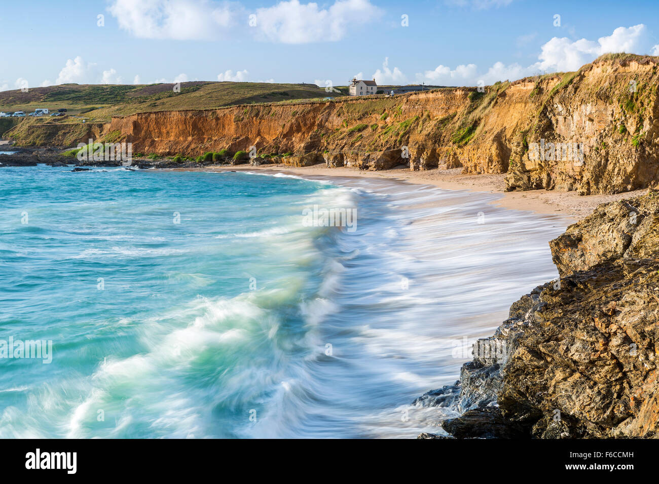 Wellen über die Felsen bei Godrevy Point, Blick auf den Leuchtturm auf der Insel Godrevy, Cornwall, England Stockfoto