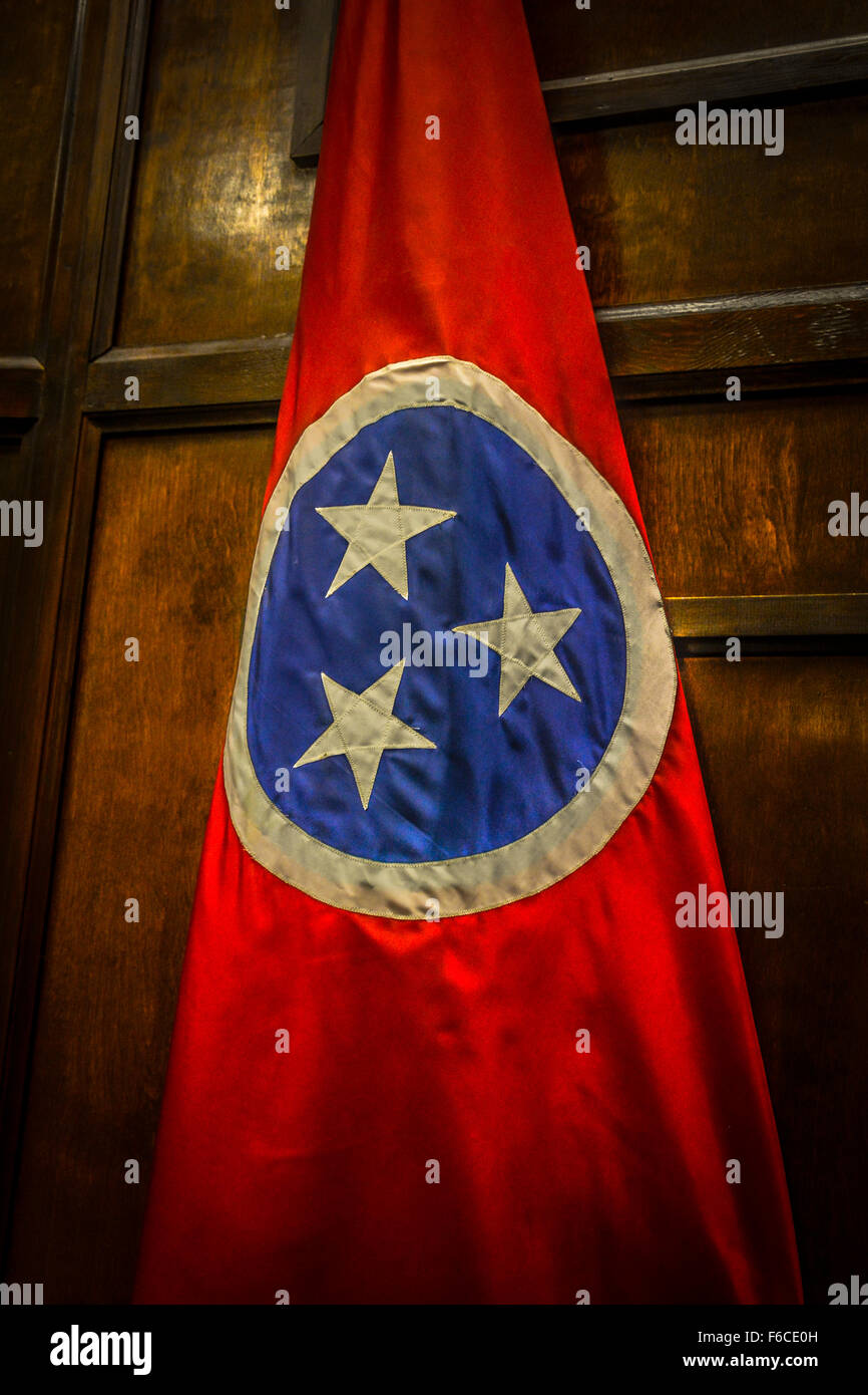 Eine bunte rote und blaue Flagge mit drei weißen Sternen in einem Kreis als Symbol für Tennessee Staatsflagge vor einer Holzwand innen Stockfoto