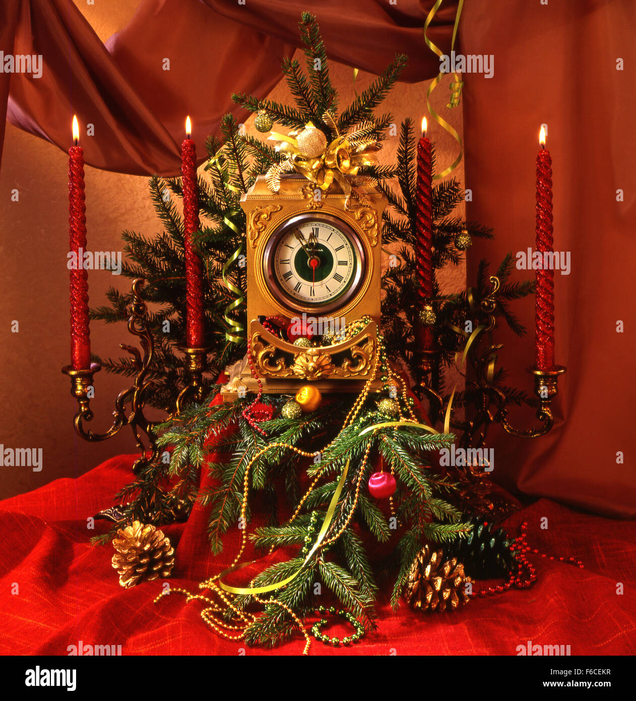 Festliches Silvester, Weihnachten Stillleben mit Weihnachtsbaum Dekorationen, Stunden, Kegel und zwei Kerzenständer mit Kerzen. Stockfoto Festliches Silvester, Weihnachten Stillleben mit Weihnachtsbaum Dekorationen, Stunden, Kegel und zwei Kerzenständer mit Kerzen. Stockfoto