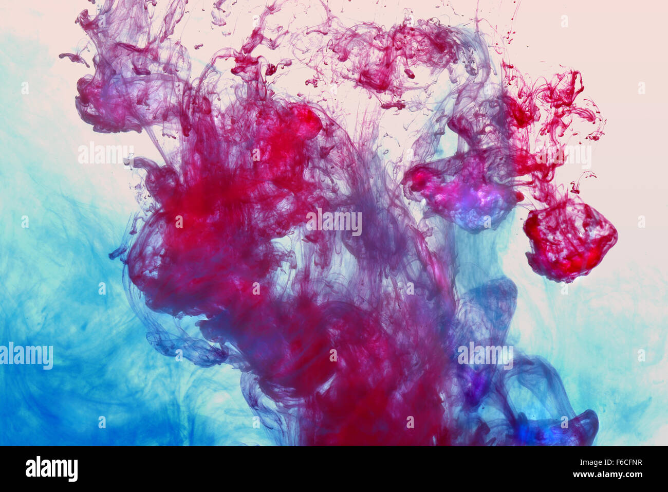 Bunte Tinte in Wasser über hellen Hintergrund Stockfoto