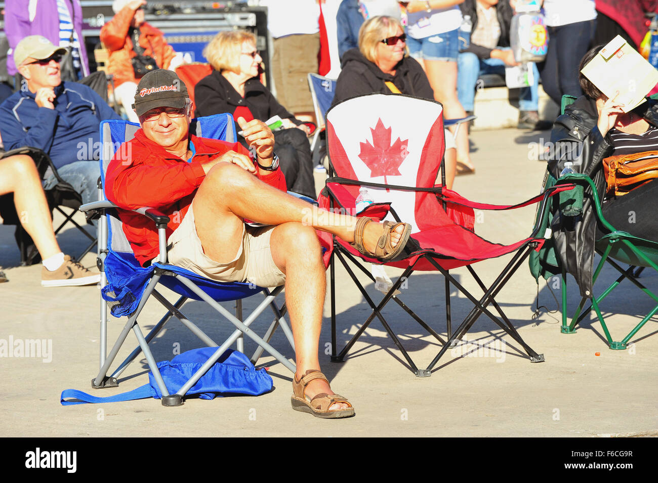 Ein Mann sitzt auf einem Klappstuhl auf eine kostenlose Musik-Event in London, Ontario. Stockfoto