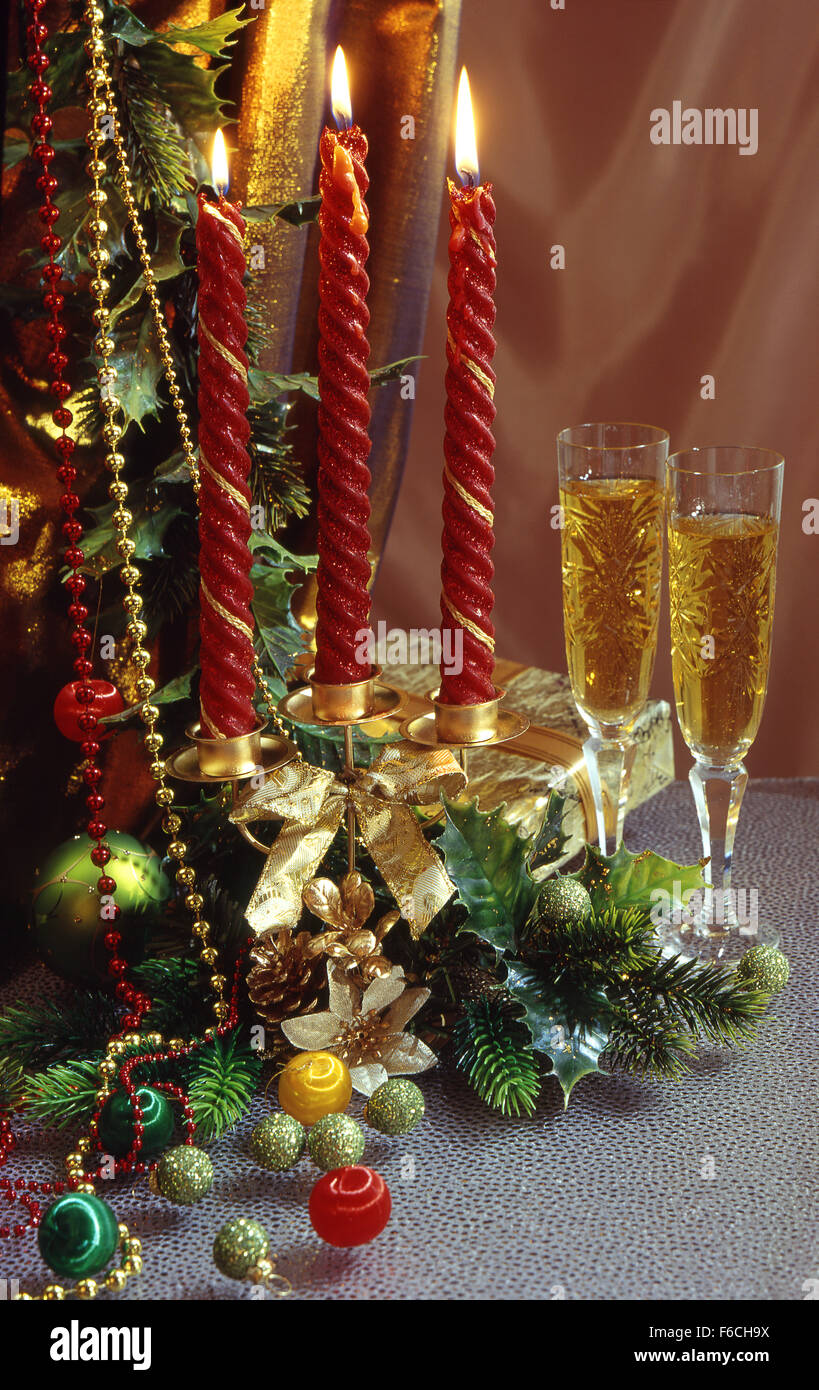 Festliches Silvester, Weihnachten Stilleben mit zwei Kristallgläser mit Wein und eine Kerze mit drei roten Kerzen. vertikale Stockfoto