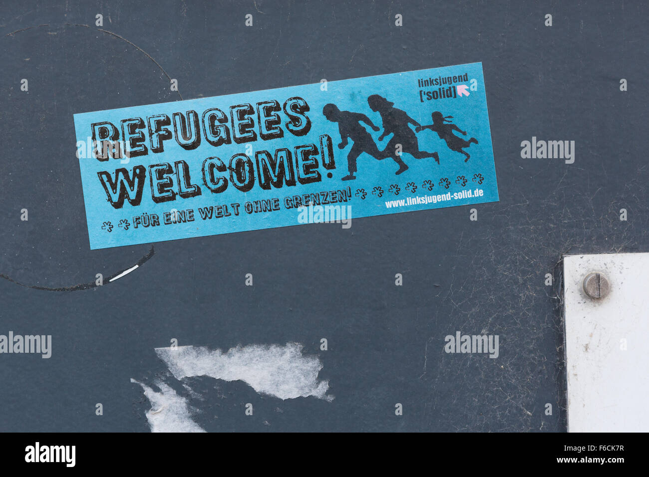 Aufkleber auf der Mauer in Deutschland sagt: "Flüchtlinge willkommen - für eine Welt ohne Grenzen" Stockfoto
