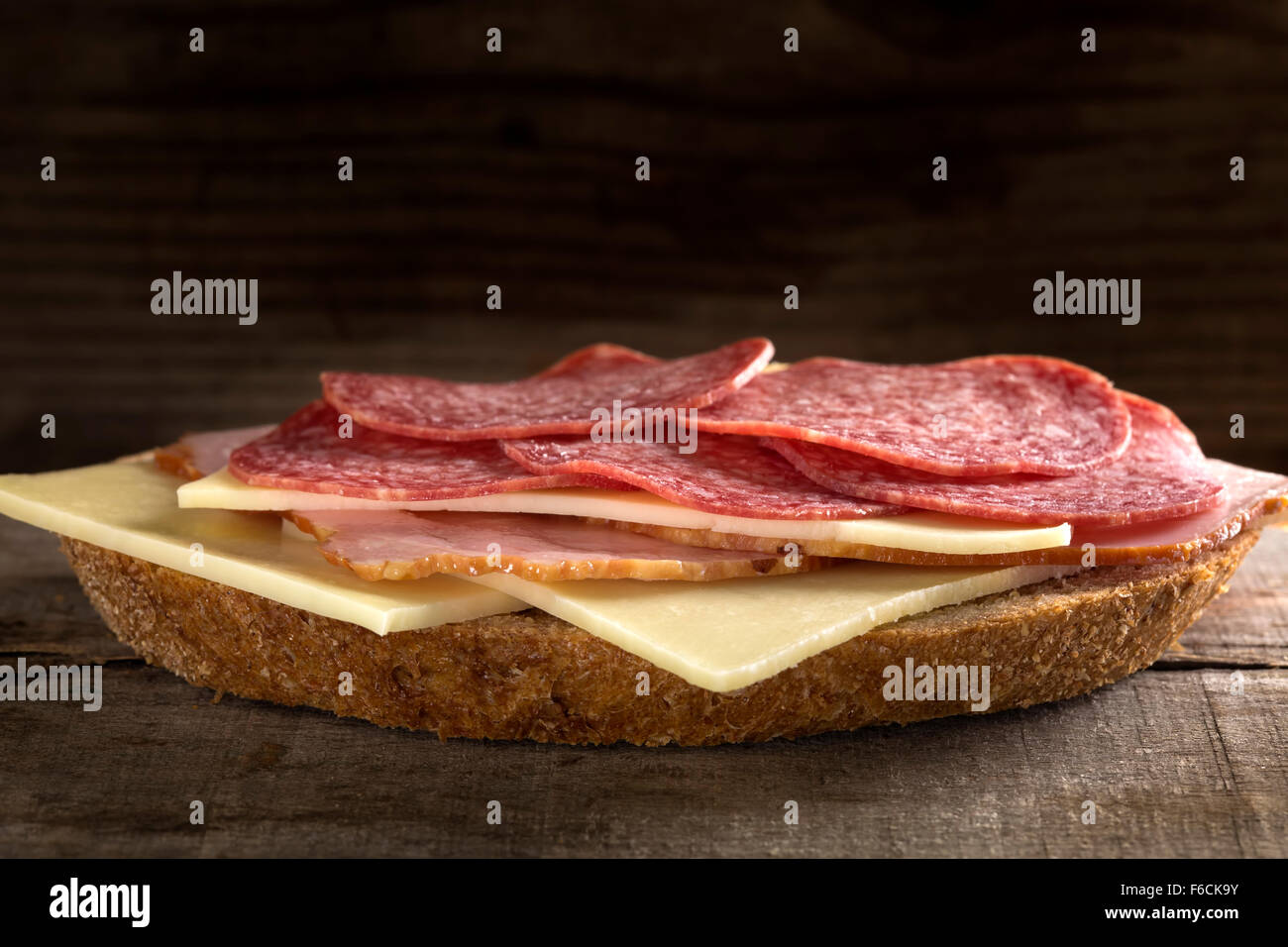 Open-Sandwich mit Schinken, Salami und Käse auf hölzernen Hintergrund Stockfoto