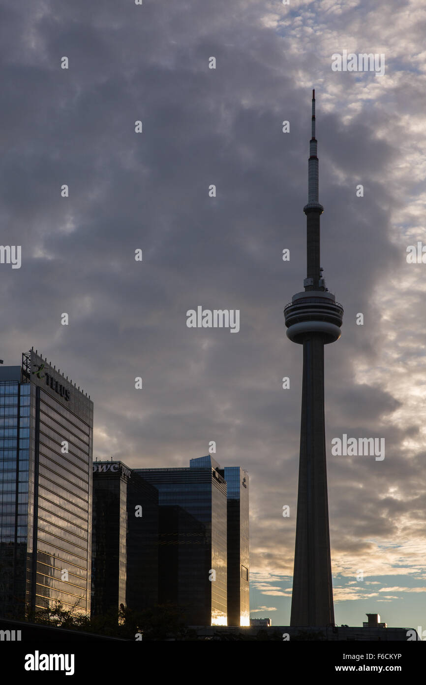 Der CN Tower Silhouette gegen ein Abendhimmel mit Stadtzentrum gelegene Gebäude reflektiert die Sonne Stockfoto