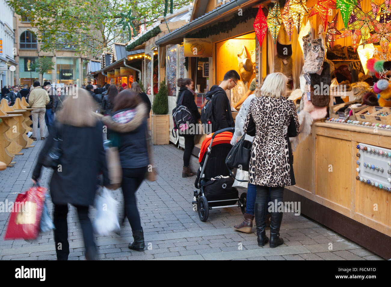 Weihnachtseinkäufer in Manchester UK, festlich dekorierte Holzchalets in St Annes Square. Geschäftiges Stadtzentrum Weihnachtsgeschäfte, Stände & Markthändler. Stockfoto