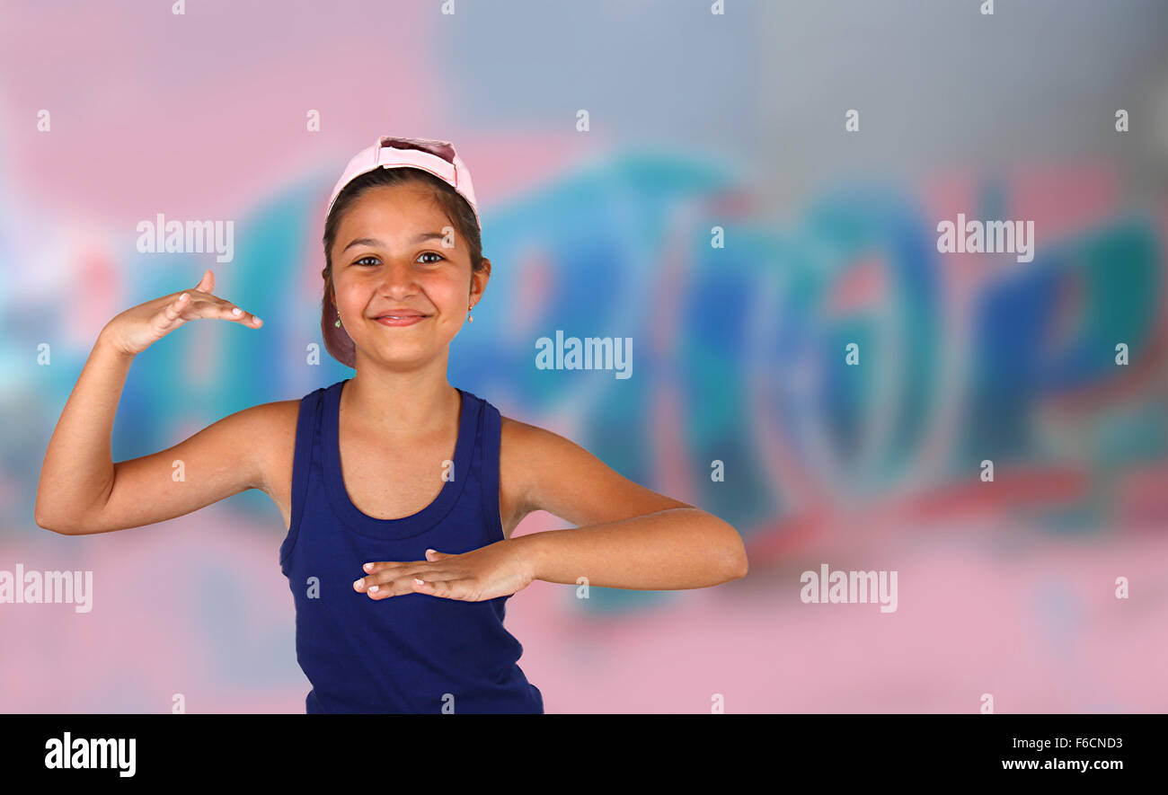Kleines Mädchen tanzen hip Hop über die Mauer mit Wandmalereien Stockfoto