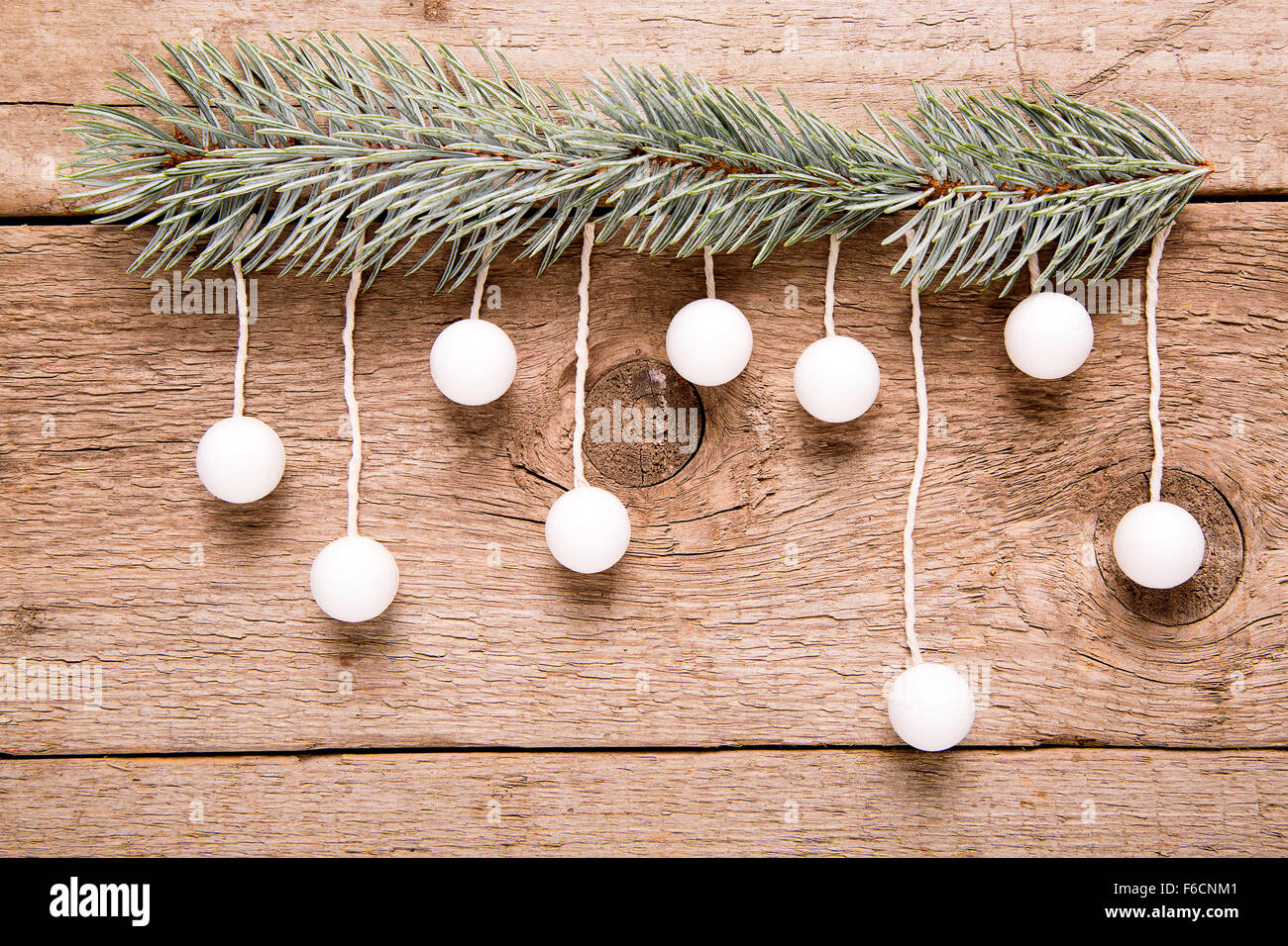 Weihnachtsgrußkarte, hängende weiße Kugel auf hölzernen Hintergrund Stockfoto