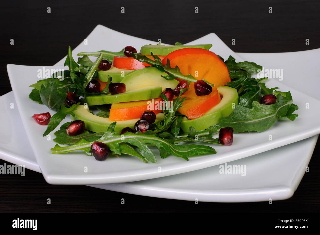 Salat mit Avocado, Grapefruit, Kaki, Granatapfel und Rucola Stockfoto