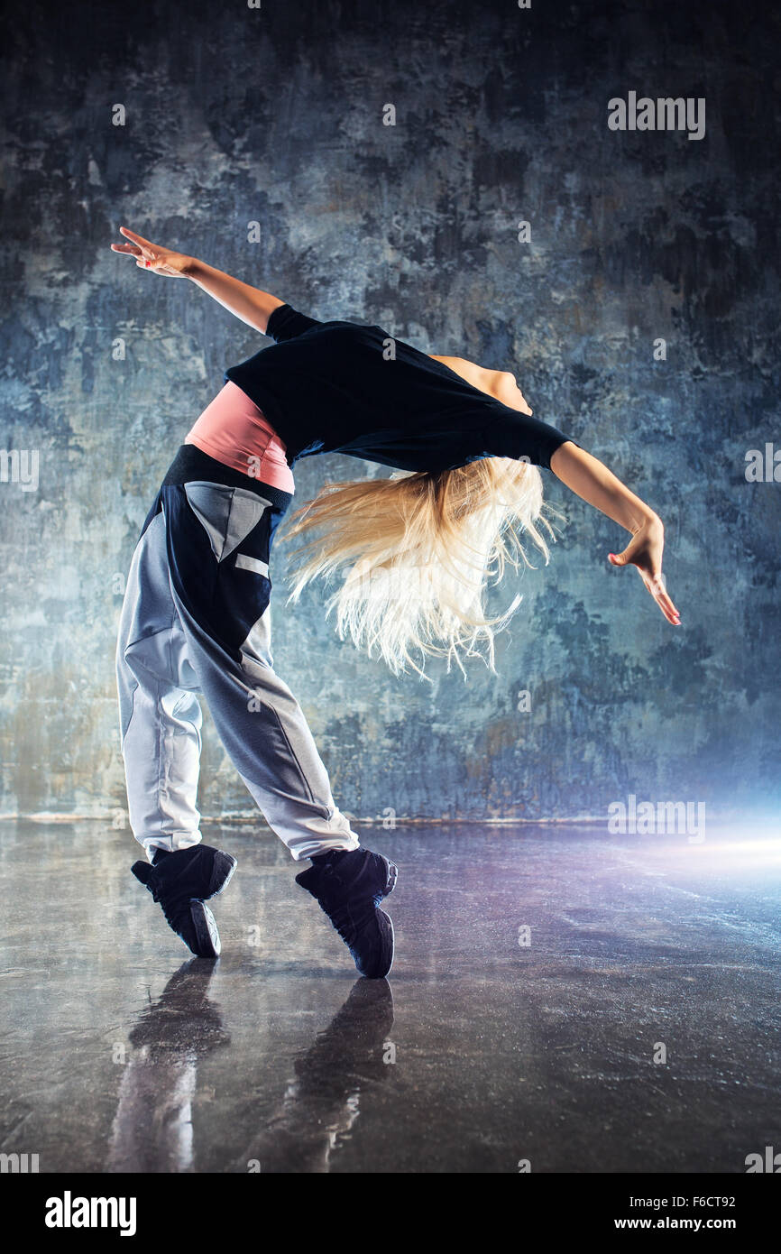 Moderne junge Frau Tänzerin. Auf Grund der Steinmauer. Stockfoto