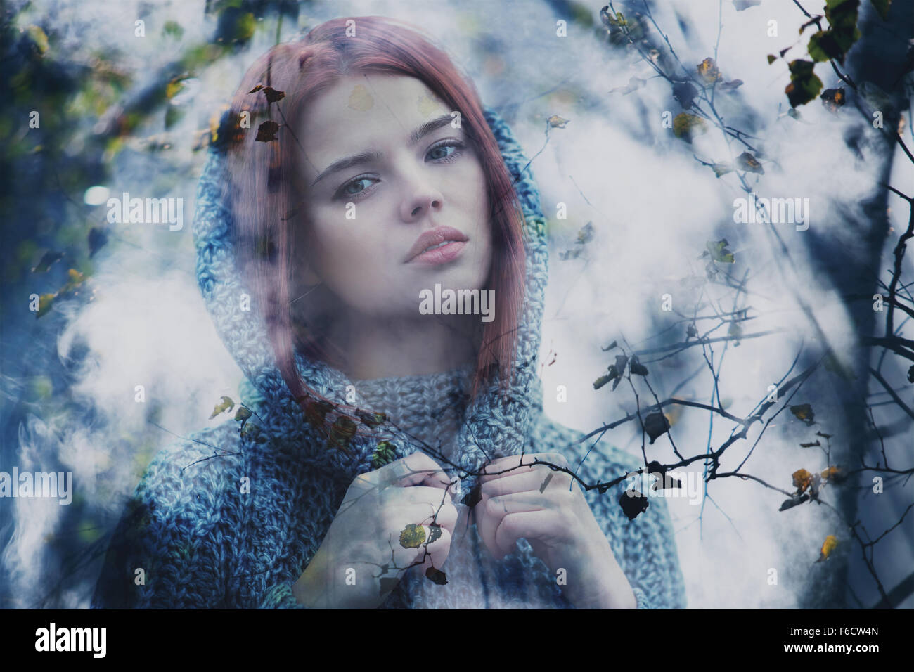 Junge ruhig Frau draußen neblig Porträt durch Herbstlaub. Stockfoto