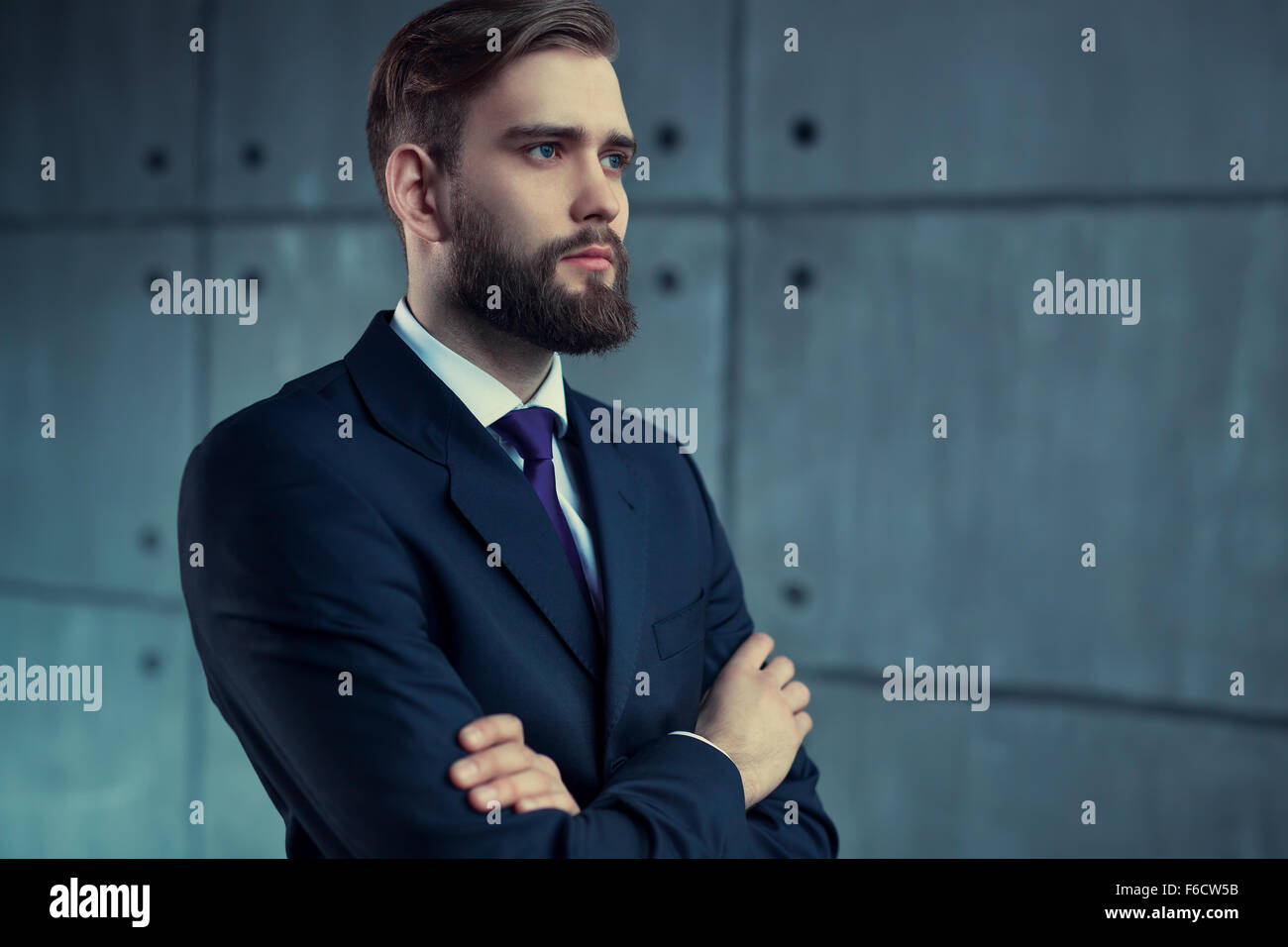 Schönen jungen Mann mit Bart im schwarzen Anzug auf der Suche zur Seite. Stockfoto