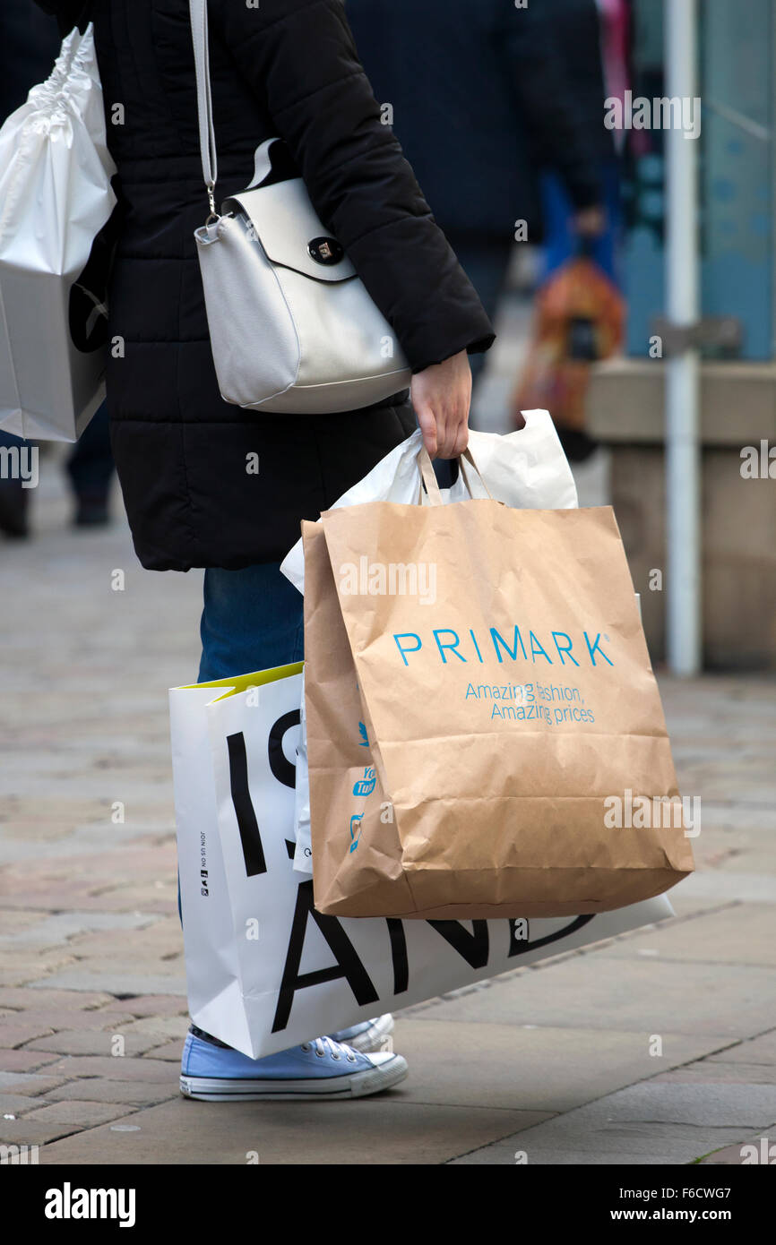Eine Frau, die mehrere Marken-shopping Taschen, River Island & Primark, am  Markt St. Piccadilly, Manchester, Uk Stockfotografie - Alamy