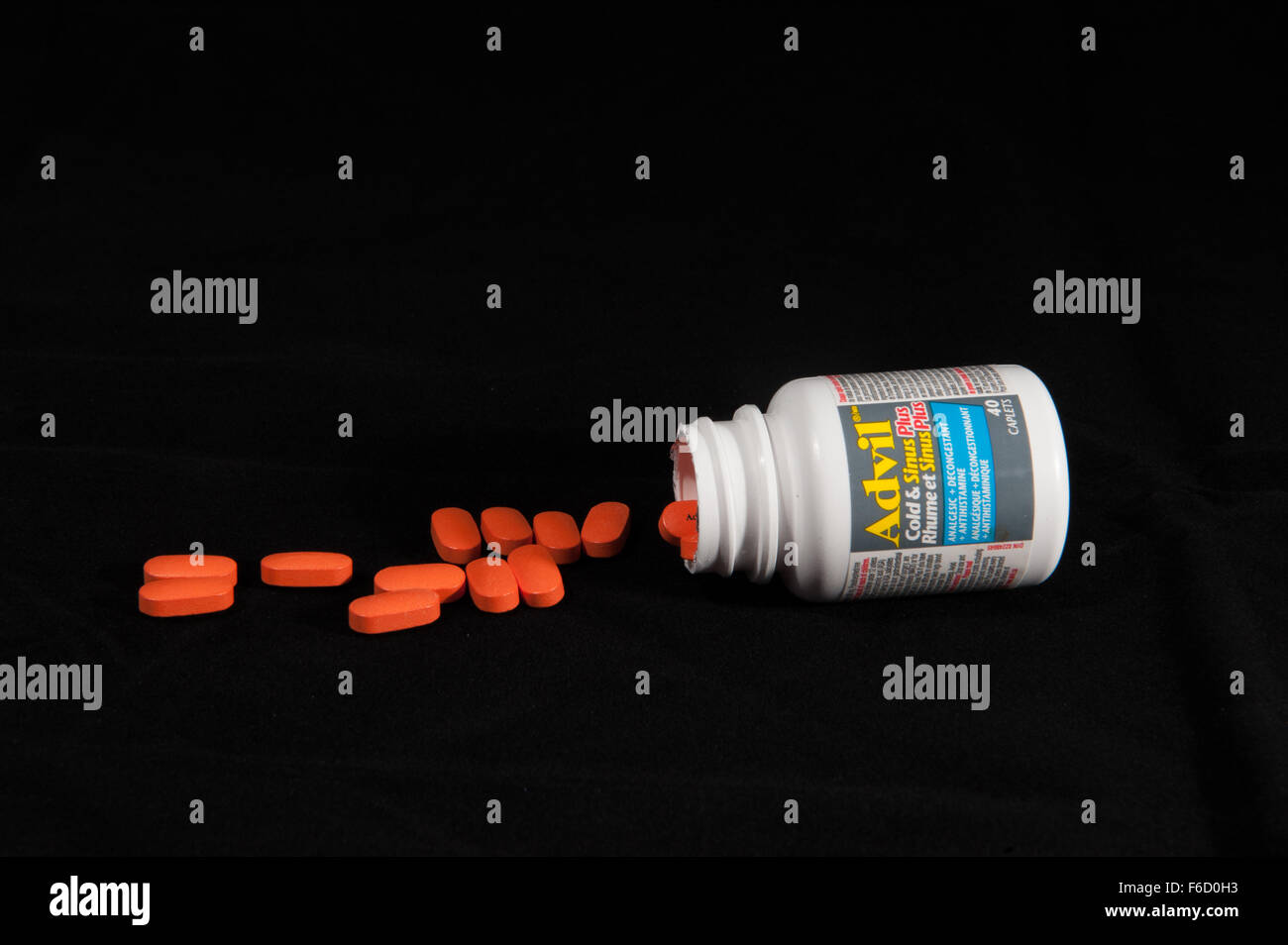 Ein Container von Advil auf seiner Seite und verschüttete Tabletten Stockfoto