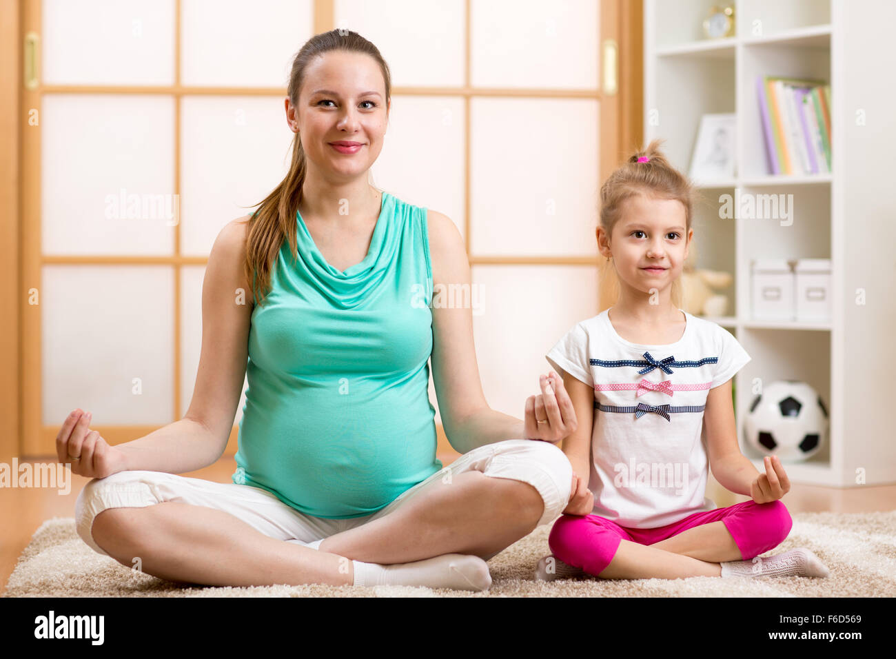 Yoga für die Frau und Kind. Mutter und Kind tun Fitness-Übung Stockfoto