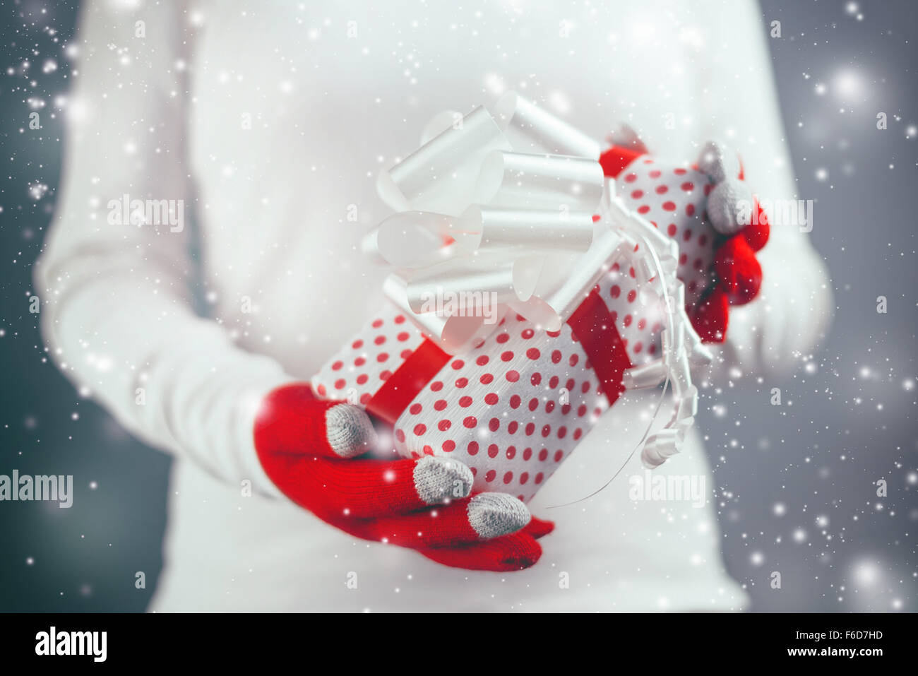 Frau mit ungewöhnlichen Weihnachtsgeschenk verpackt Box, Ferienzeit mit Schneeflocken fallen, Retro getönten Bild mit Tiefenschärfe Stockfoto