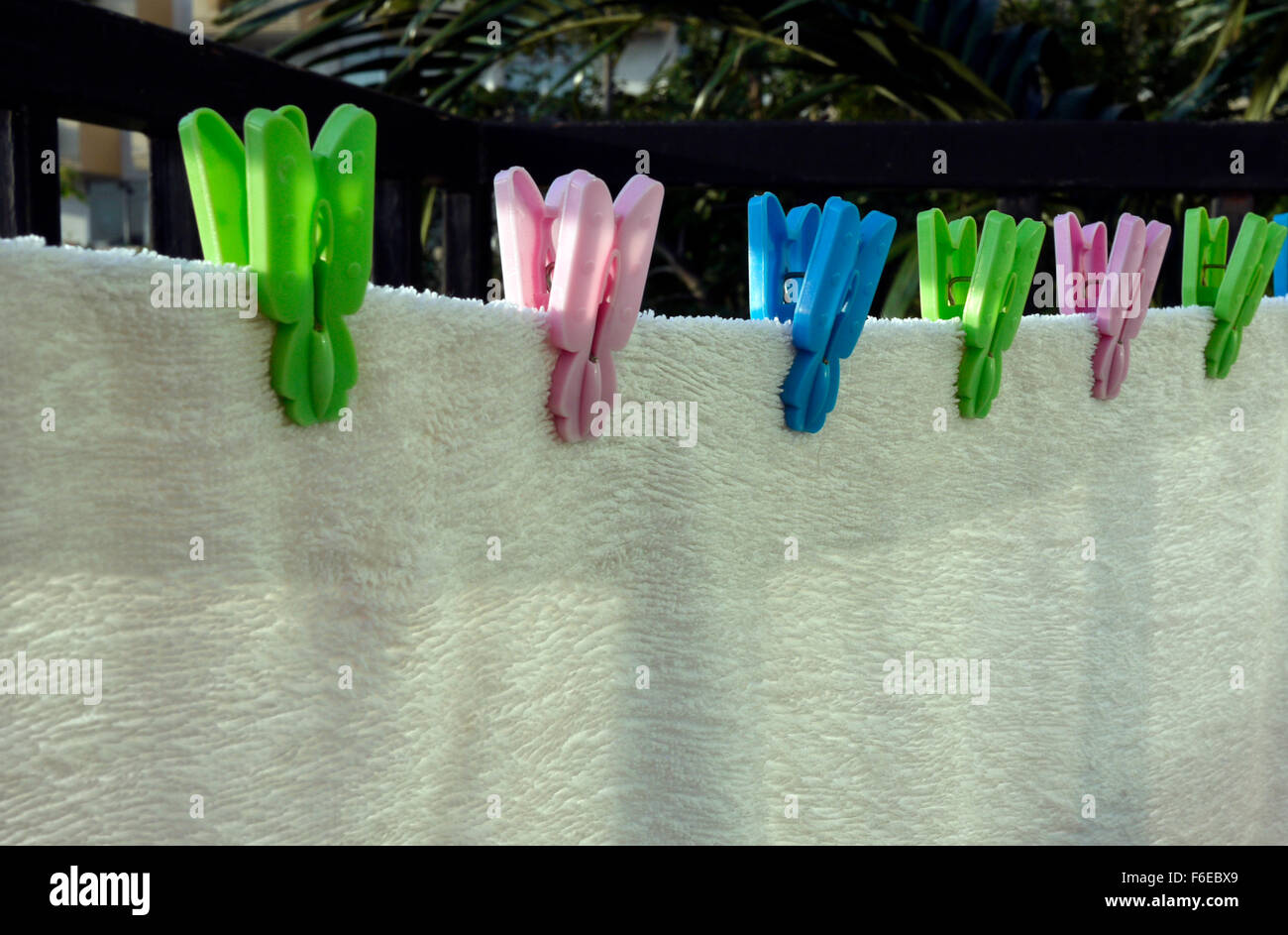 Ein weißes Handtuch trocknen auf dem Hotelbalkon mit Kunststoff Wäscheklammern gegriffen Stockfoto