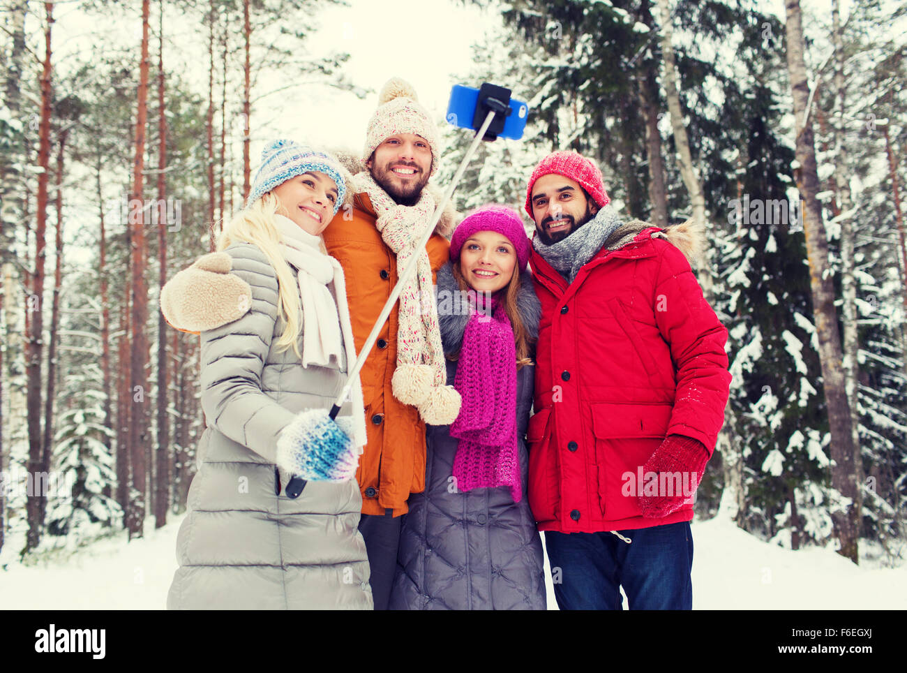 lächelnden Freunde mit Smartphone im Winterwald Stockfoto